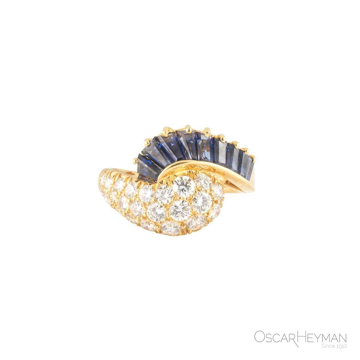 A beautiful 18k yellow gold Oscar Heyman diamond and sapphire ring. The ring comprises of 9 tapered baguette cut and emerald cut sapphires with a total weight of 1.35ct. Complimenting the sapphires are 23 round brilliant cut diamonds tappering in