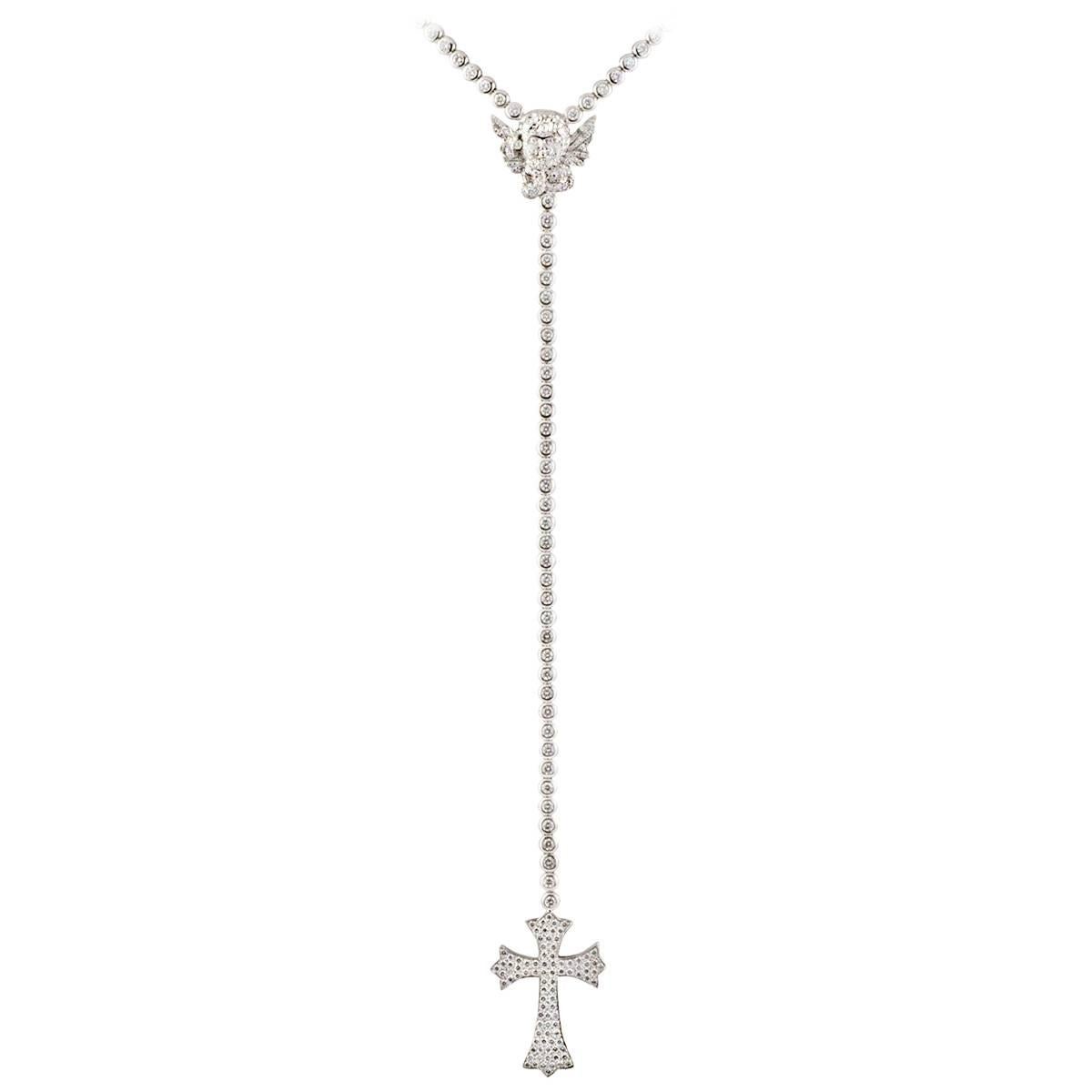An 18k white gold diamond set necklace by Edouard Nahum. The necklace is set to the centre with an angel motif, pave set with 144 round brilliant cut diamonds. Suspending from the angel is a freely moving chain made up of 38 round brilliant cut