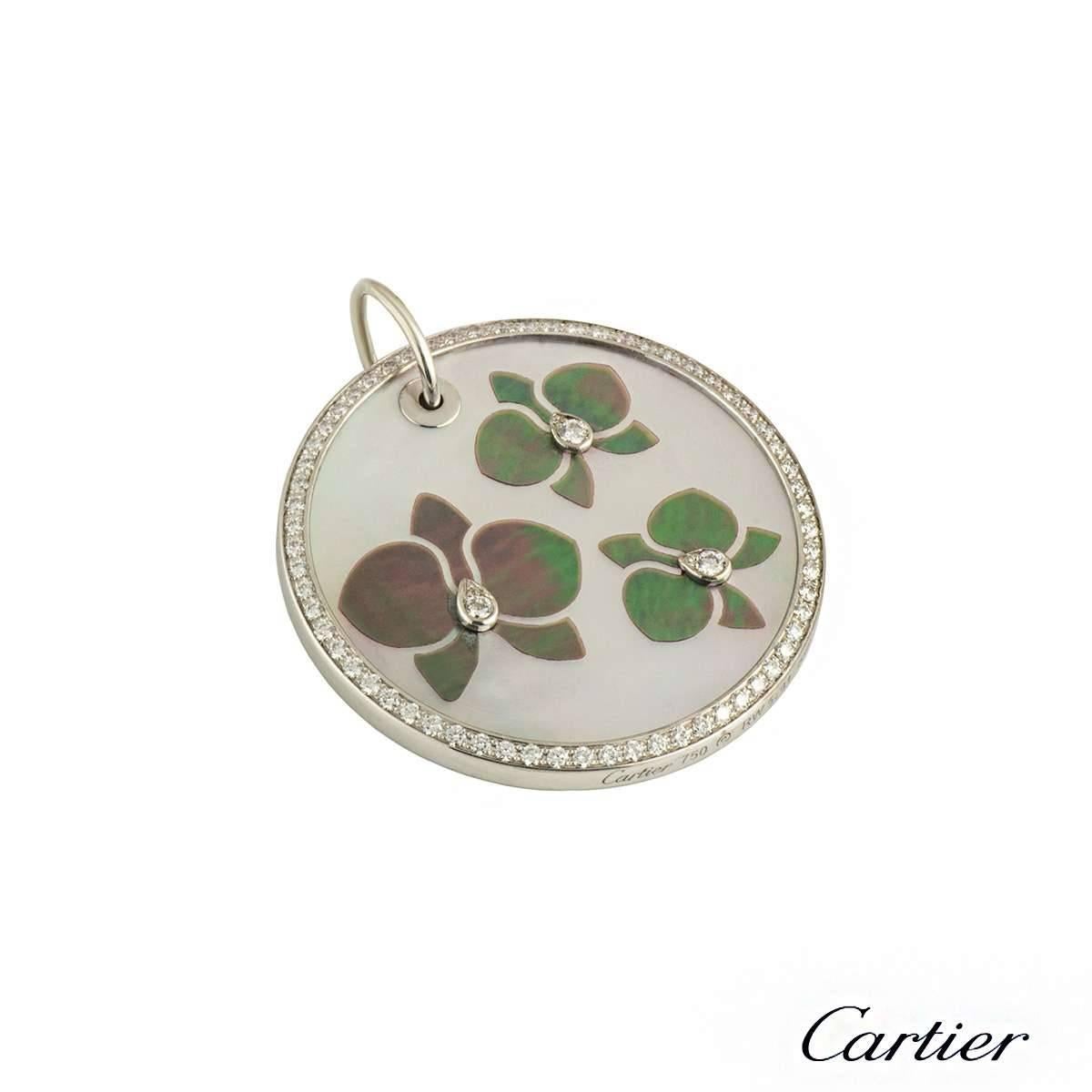 A beautiful 18k white gold Cartier diamond and mother of pearl pendant from the Caresse D'Orchidees collection. The pendant comprises of a circular mother of pearl motif with 3 orchid motifs consisting of a round brilliant cut diamond in the centre