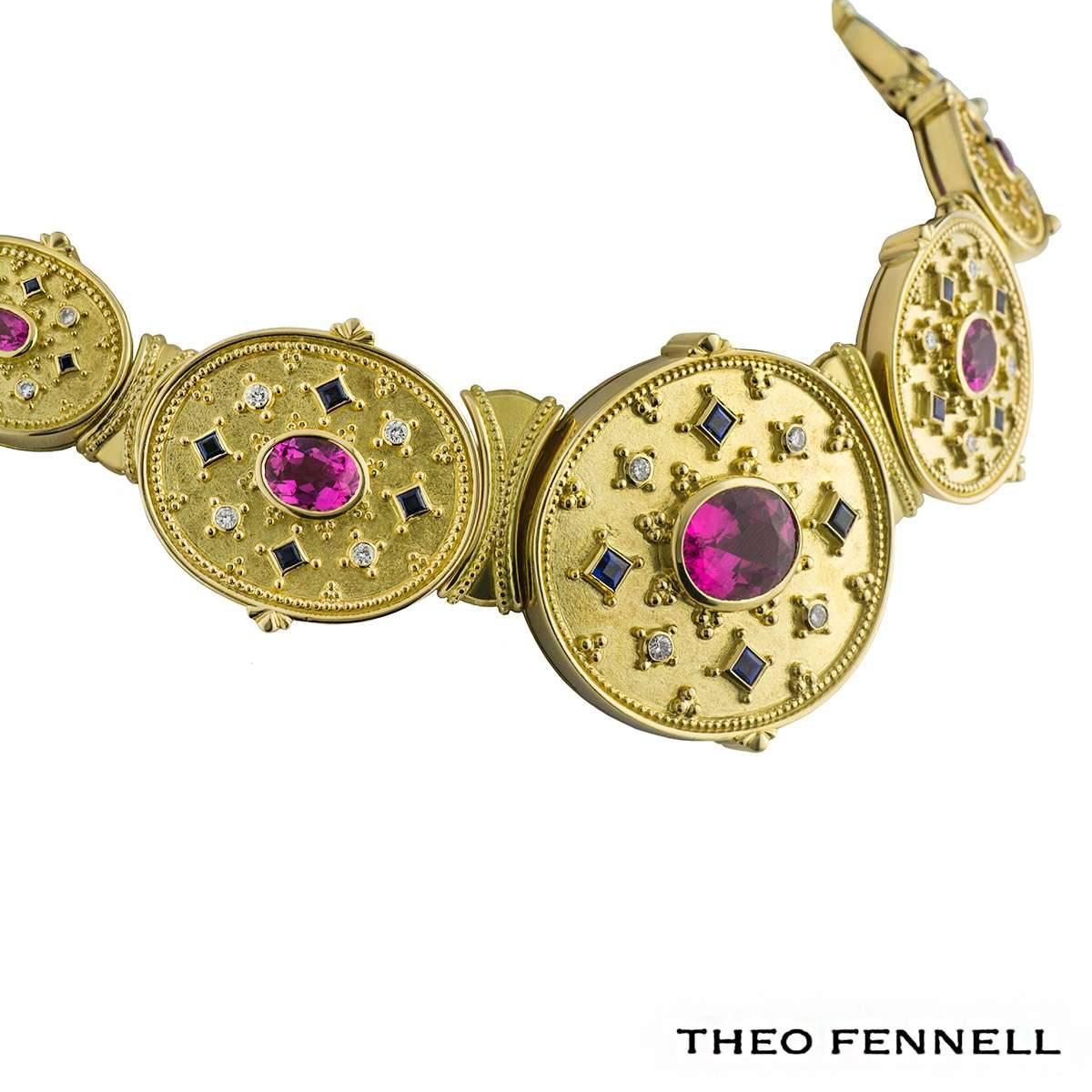 A vintage 18k yellow gold Theo Fennell diamond sapphire and tourmaline necklace and earrings. The necklace comprises of a oval gold motif set to the centre with a oval cut pink tourmaline in a rubover setting with 4 round brilliant cut diamonds and