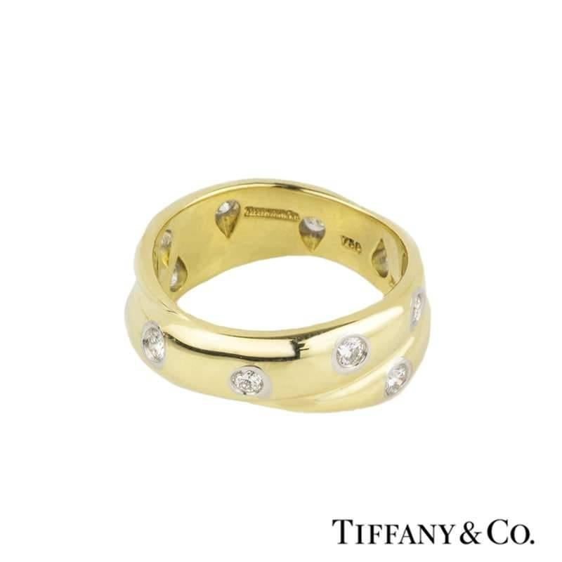 A beautiful 18k yellow gold diamond set crossover ring from the Tiffany & Co Etoile collection. The ring is set with 11 round brilliant cut diamonds evenly scattered throughout the ring, each set in a platinum rub-over setting, totaling