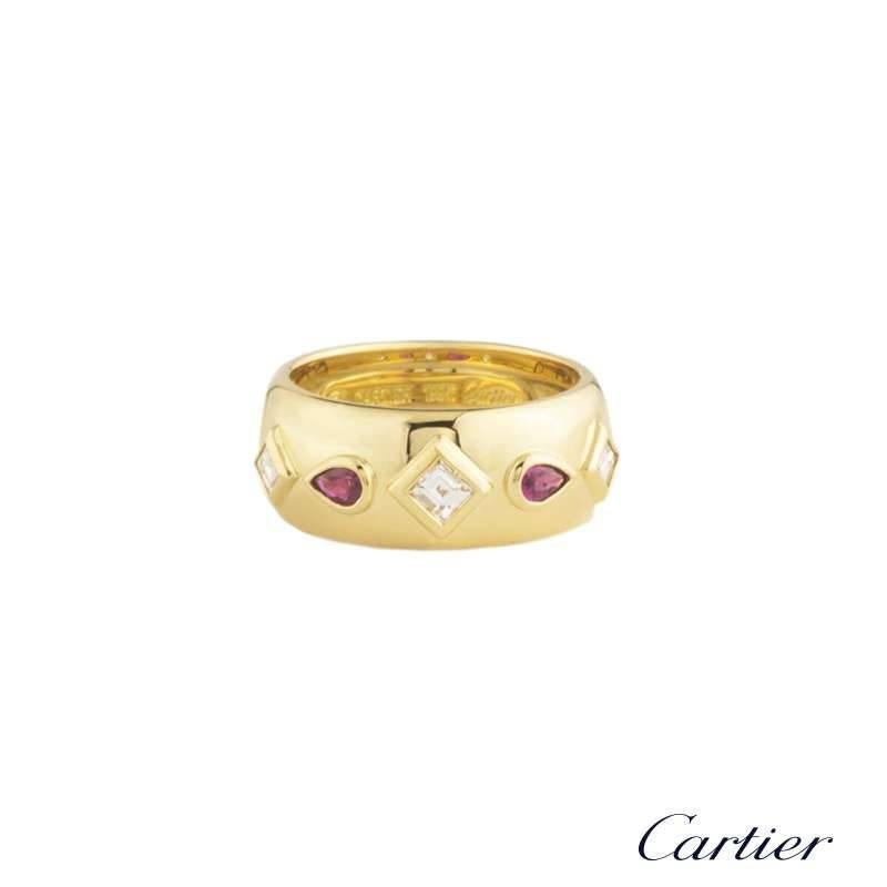 A stunning 18k yellow gold diamond and ruby dress ring by Cartier. The ring is set with 3 rub-over set, princess cut diamonds totalling approximately 0.40ct, F/VS, alternating between two pear shaped rubies totalling approximately 0.40ct, of which
