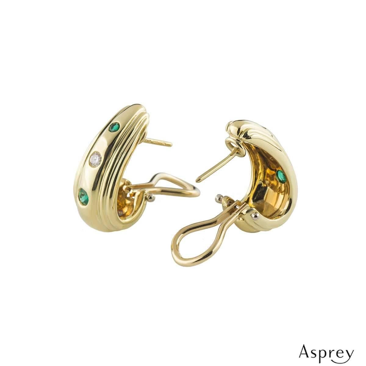 A stylish pair of 18k yellow gold diamond and emerald earrings by Asprey. The earrings comprise of a gold hoop with 2 round brilliant cut emeralds set vertically in a tension setting, alternating with a round brilliant cut diamond also in a tension