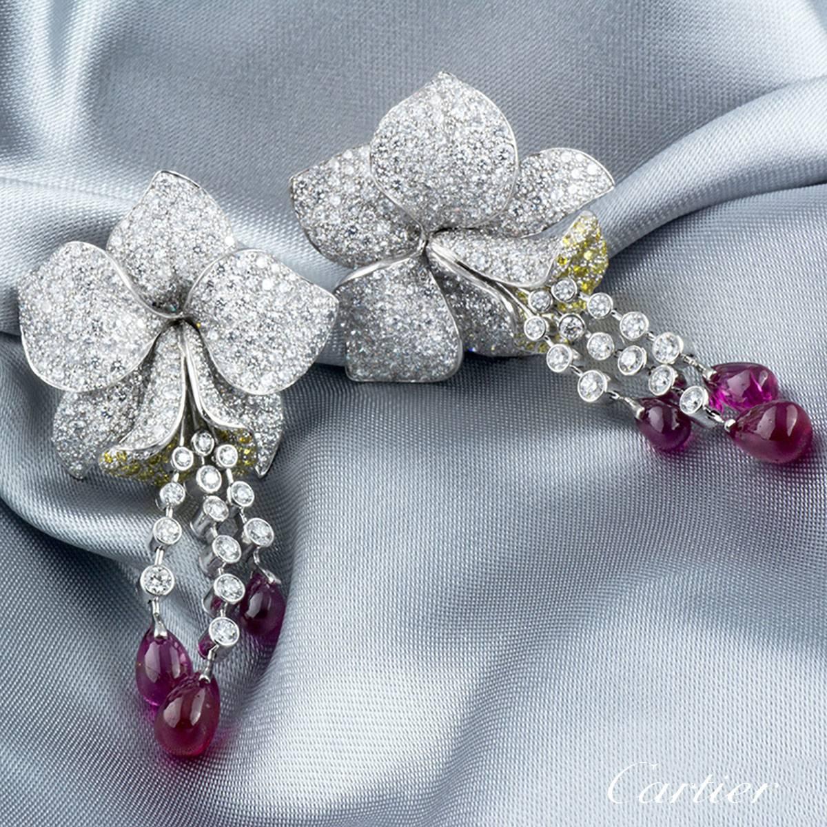 A luxurious and extremely rare pair of platinum Cartier earrings from the Caresse D' Orchidees collection. Each earring comprises of an Orchid motif with 5 petals embellished with round brilliant cut diamonds. The lip of the orchid is detailed with