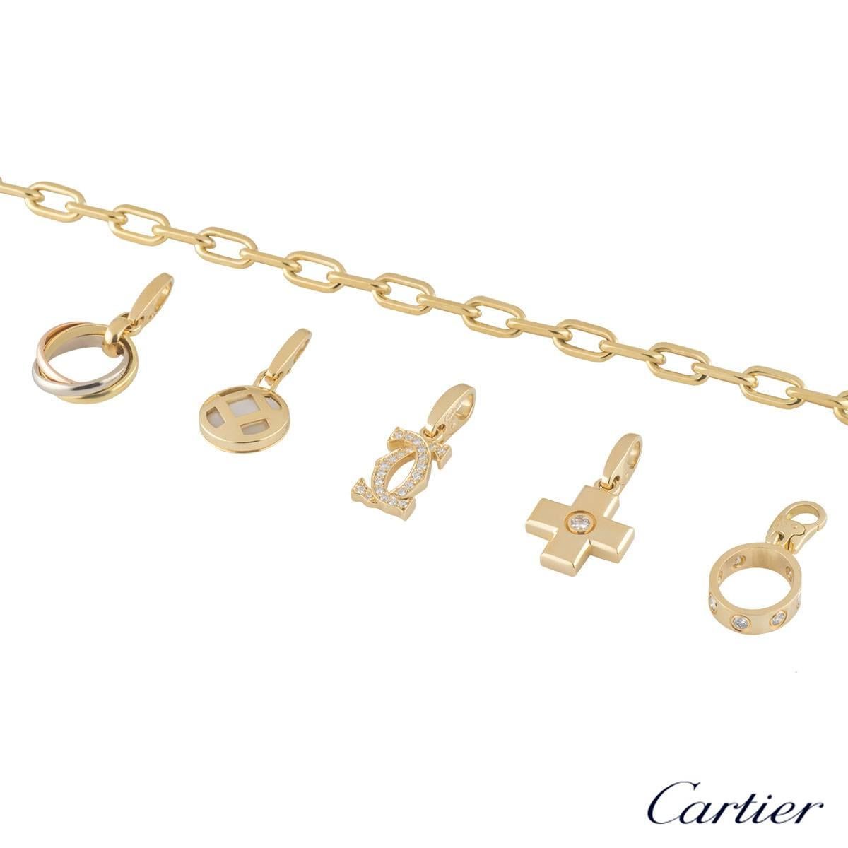 A unique 18k yellow gold Cartier charm bracelet. The bracelet comprises of a yellow gold flat cable chain with 5 Cartier charms. The first charm is a mini trinity de cartier ring in tri colour gold. The second charm is a mini pasha motif with a