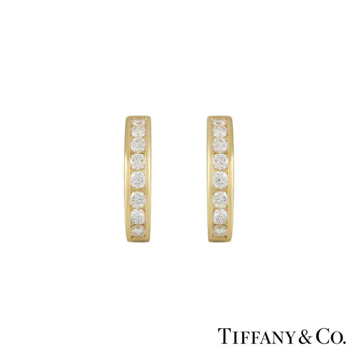 A beautiful pair of diamond set hoop earrings by Tiffany & Co. The hoops are channel set with 8 diamonds in each hoop and totals to approximately 0.96ct. The earrings feature post and clip fittings and measure 18mm in height and 3.7mm in width and