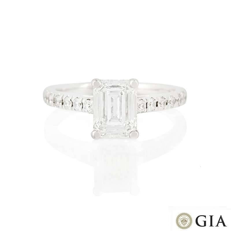 An 18k white gold diamond ring. The ring is set to the centre with an emerald cut diamond weighing 1.34ct, G colour and VS in clarity set within a classic four claw mount. The central stone is complemented by round brilliant cut diamond shoulders