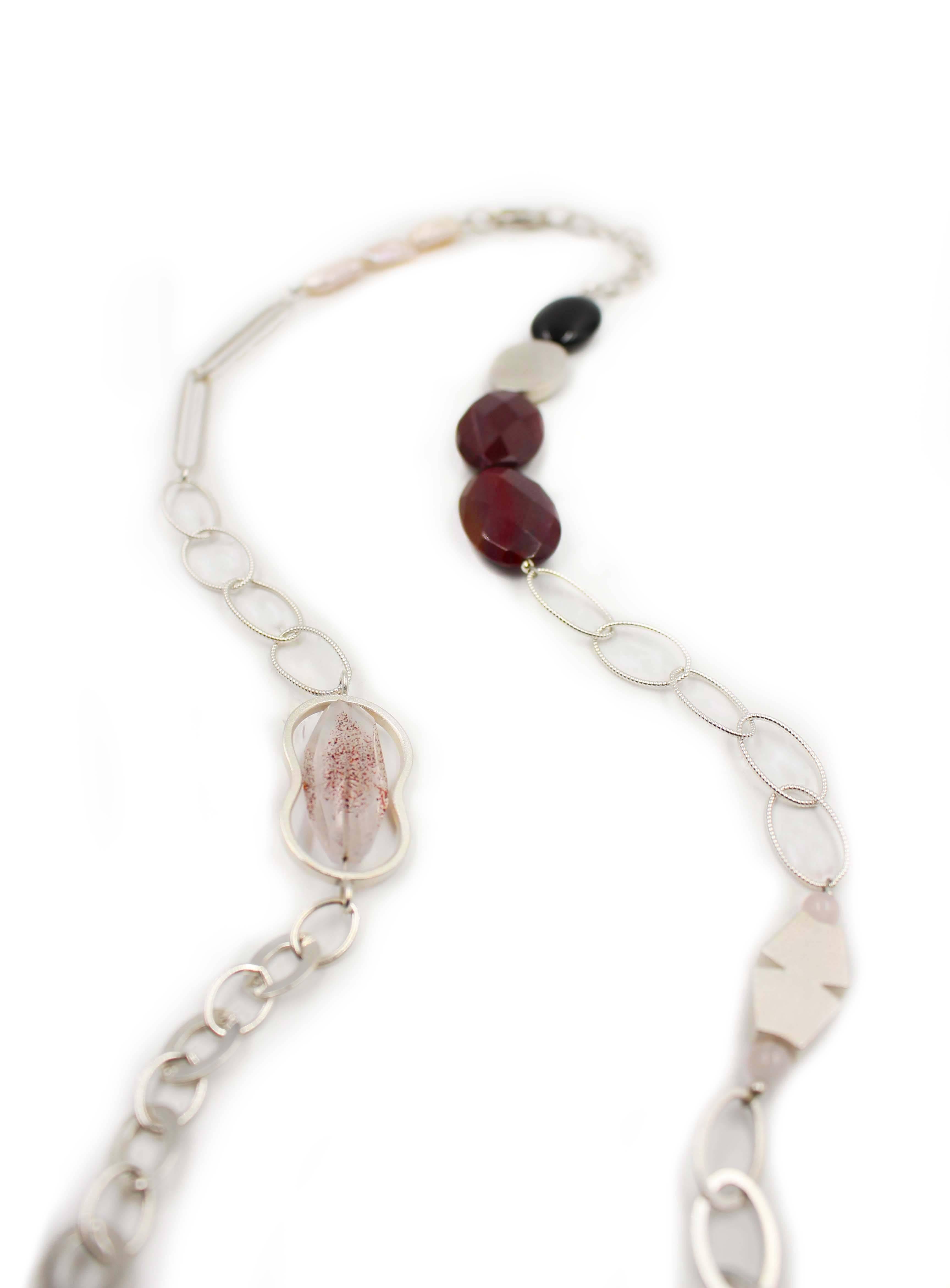 The Cranberry Garnet & Sterling Silver Necklace features handmade sterling silverloops, beads and chain set with a delightful array of gemstones including garnet, agate, onyx, pearl, and rutilated strawberry quartz.

In 1975 Janis Kerman had