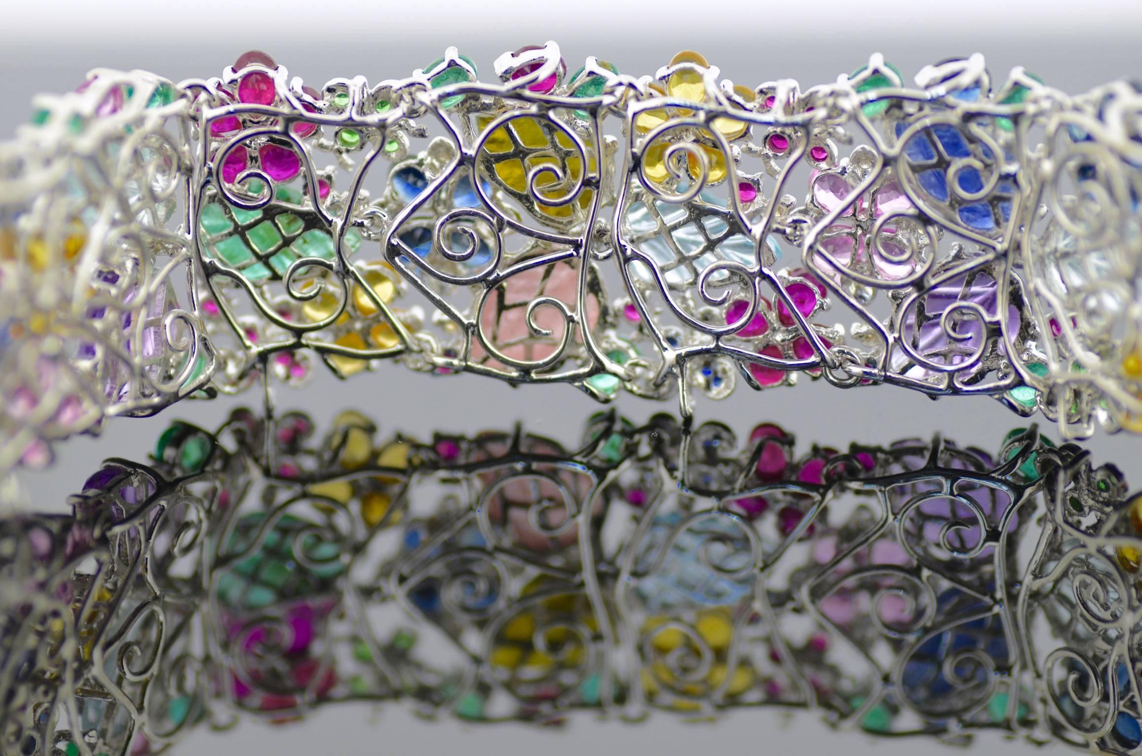 A stunning carved gems and diamond bracelet  with numerous oval, pear, cabochon and circular-cut rubies, sapphires, emeralds, amethysts, tsavorites, citrines and brilliant-cut diamonds, set in 18k white gold. Colour: Top (F-H). Clarity: