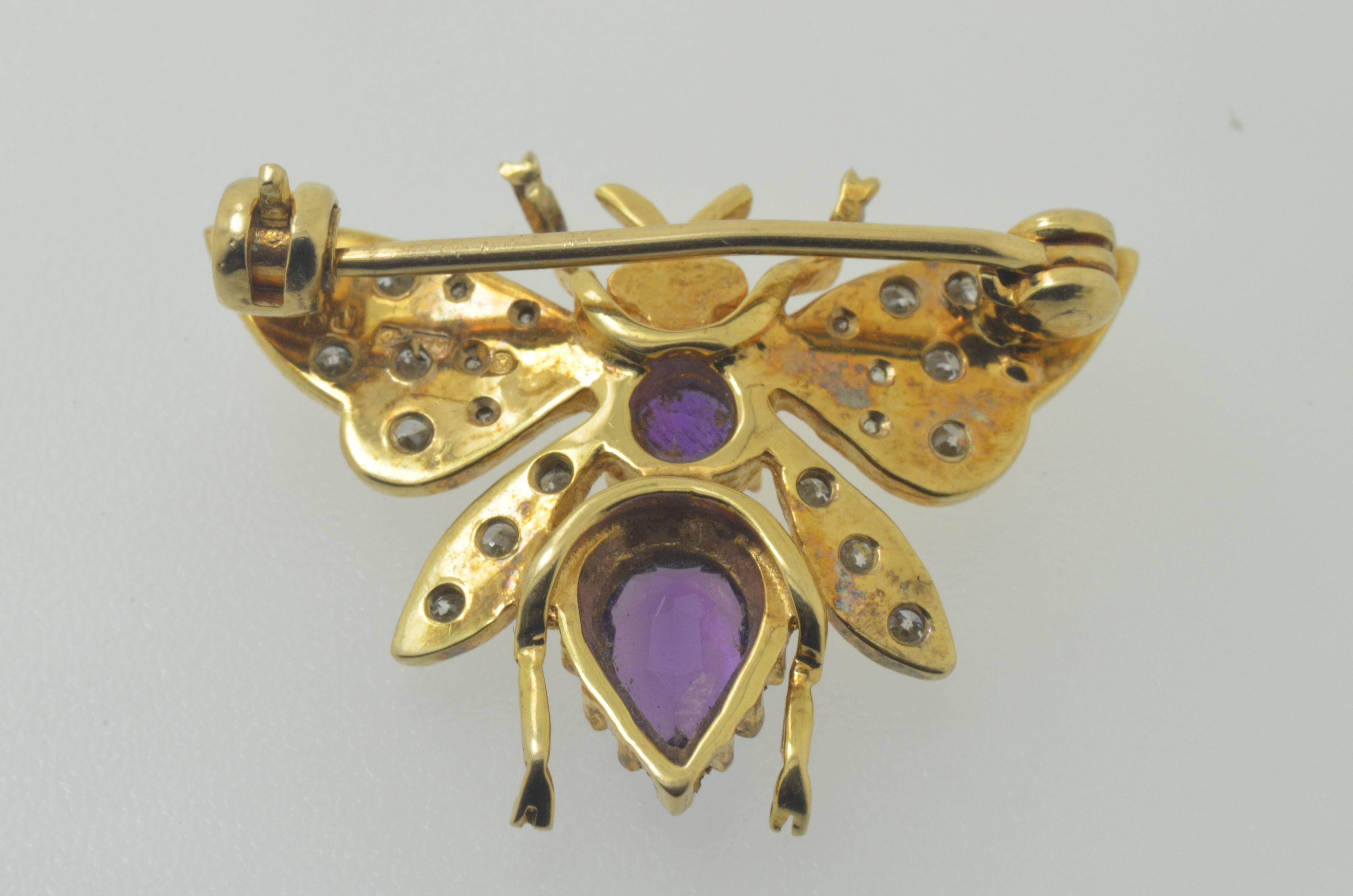An 18 karat yellow gold brooch set with 24 clean white brilliant cut diamonds, ruby eyes and amethyst body. 