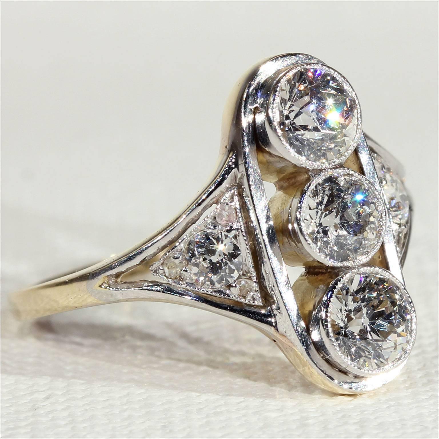 This antique Edwardian beauty is set with five old European cut diamonds, totaling approximately 1.7 carats. Made circa 1915, this ring was crafted in England. The three center diamonds are bezel set, all five diamonds are set in platinum while the