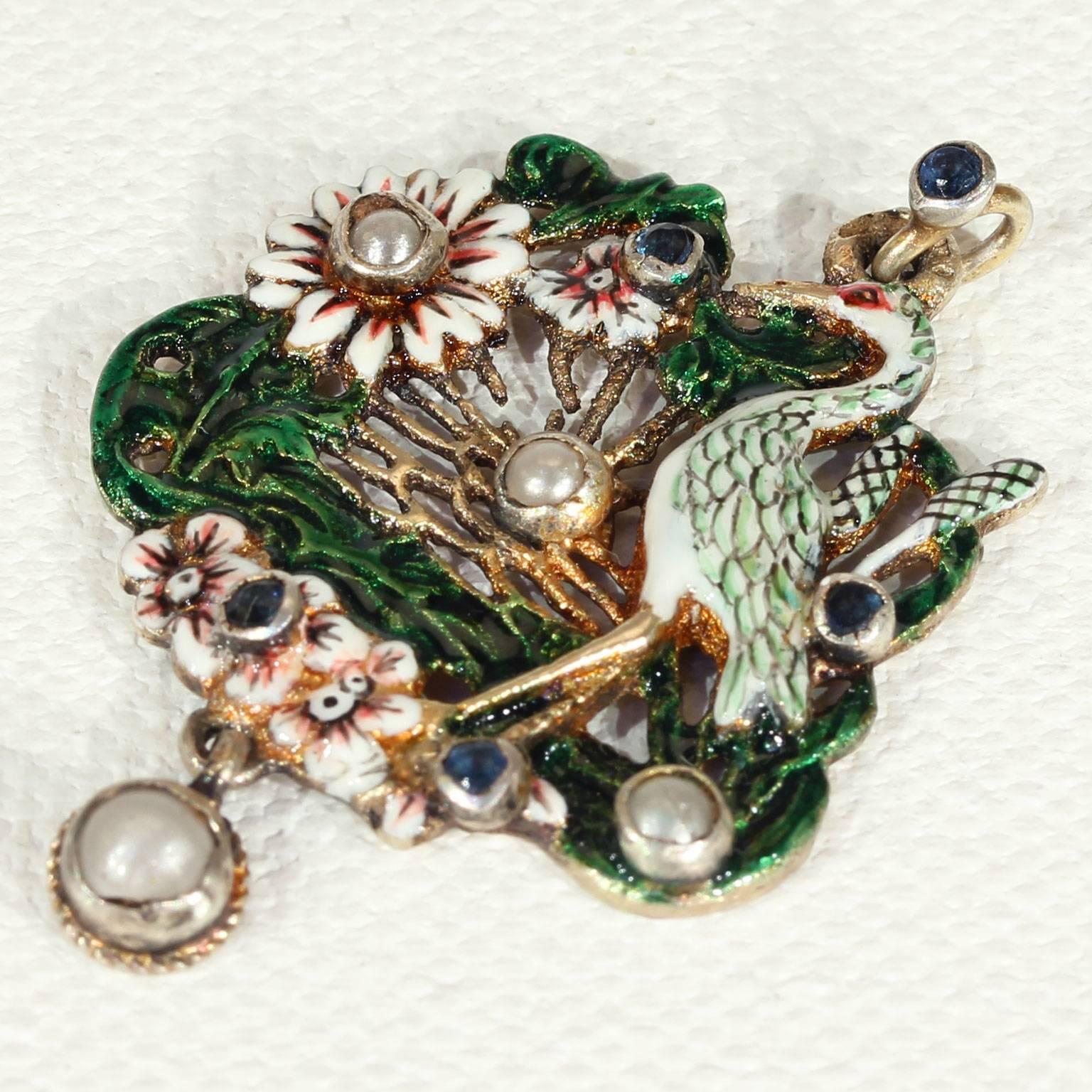 This fabulous antique Austro-Hungarian enamel pendant was handcrafted around 1870, and set in silver gilt. The highly-detailed stork motif shows the majestic bird in a detailed wonderland of flowers, set with pearls and sapphires. There’s a total of
