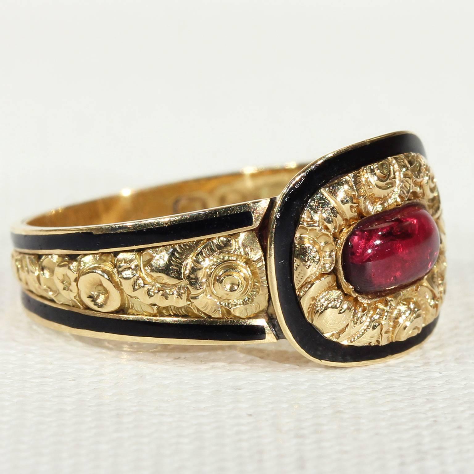 This beautiful antique Georgian memorial garnet and gold ring is fully hallmarked for having been hand crafted in 1821. It was made in 18 karat gold and features black enamel around the edges of the band and face. The entire outside of the ring is