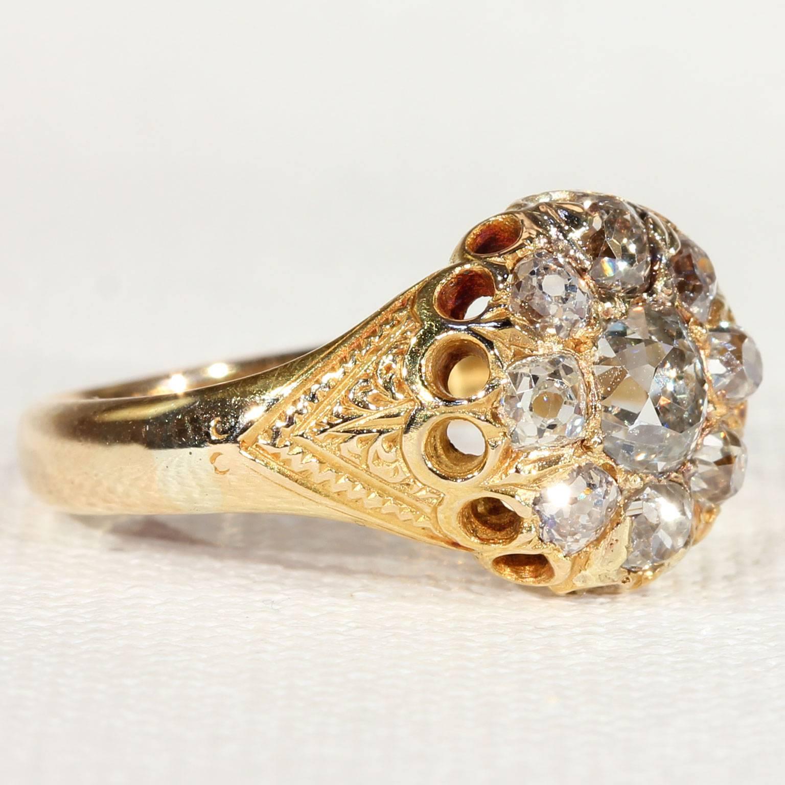 Hand crafted in Birmingham, England in 1874, this 18 karat gold ring is set with 9 bright and sparkling Old European cut diamonds that glitter and sparkle with your every move. The center stone measures 5 x 4.65 x 3.8 mm and weighs approximately .75