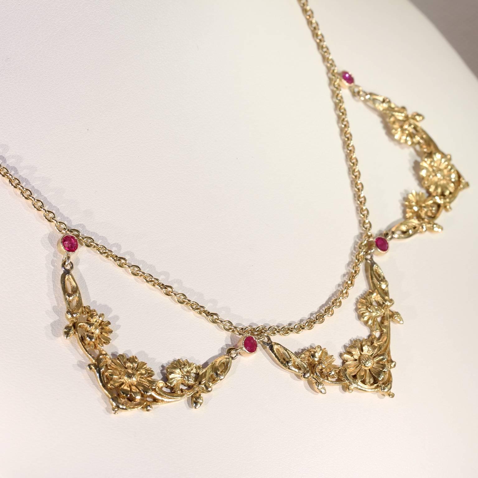 This antique ruby and 18 karat gold necklace was handcrafted in France, around 1900. It features a flower motif that dips down not once, not twice, but three times, as though it’s a garden vining around your neck. The design holds four bright pink