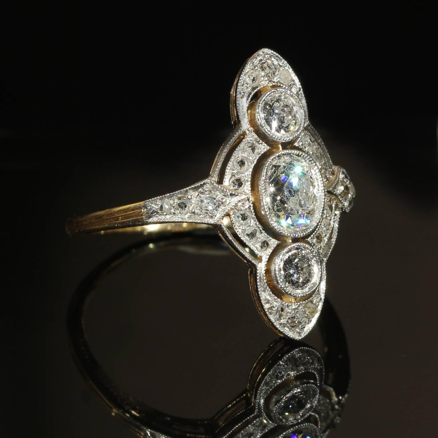 This breathtaking Edwardian era antique diamond marquis (navette) shaped ring was handcrafted around 1910. Each of the 27 white Old European cut diamonds are set in platinum, while the back and band are crafted in 14 karat yellow gold. The center