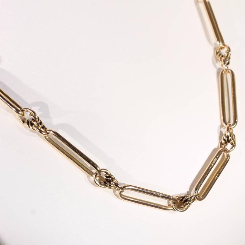 This antique Victorian gold link chain was handcrafted in England around 1890. All but four of the links are made in 15 karat gold and measure 24 x 6.4 mm each. At one point during the history of this beautiful antique chain, four more links were