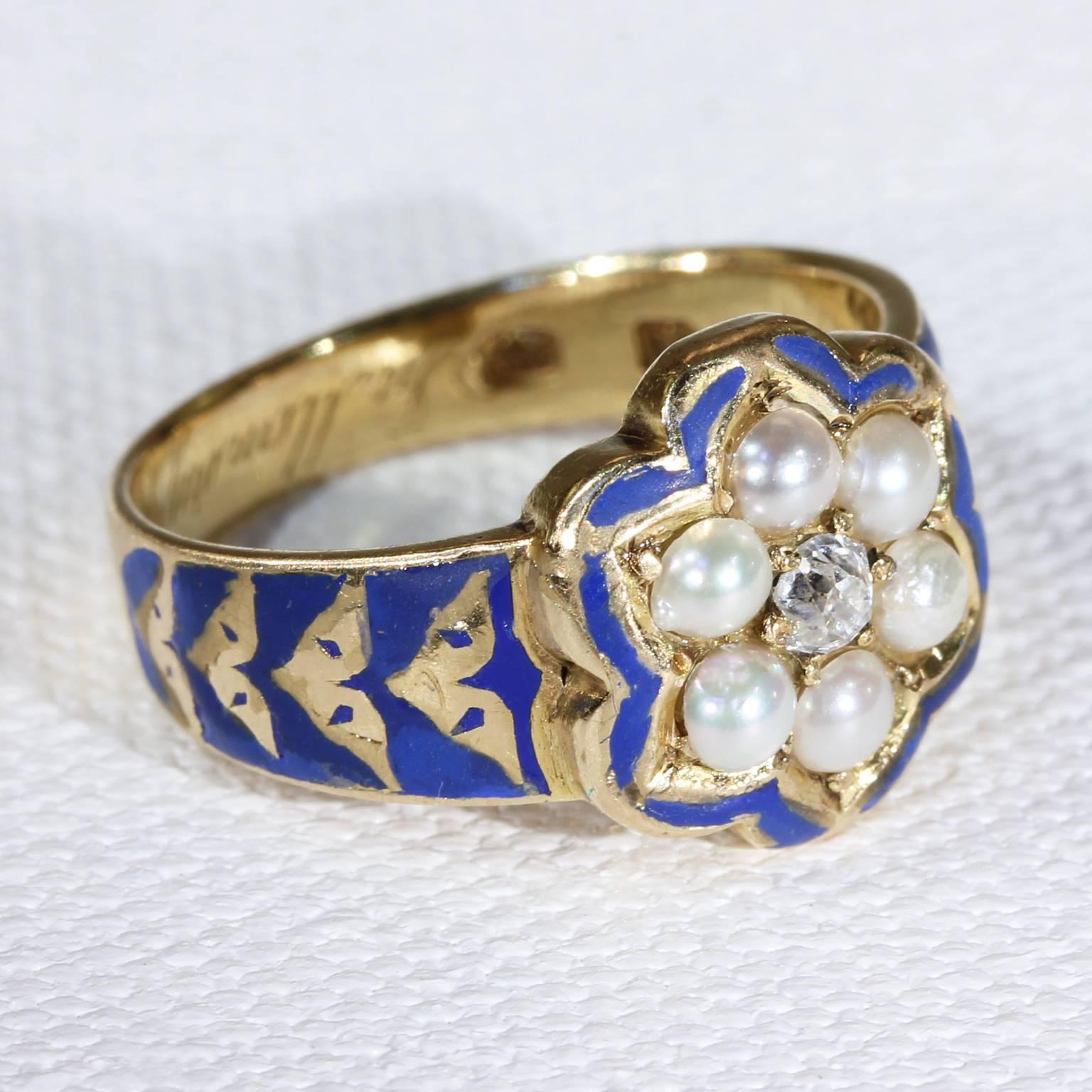 This lovely example of a mourning ring is set with six creamy white pearls, each 3 mm in diameter and one old European cut diamond at the center. It is unusual in that it is done in blue enamel, normally we see black or white on memorial rings. The