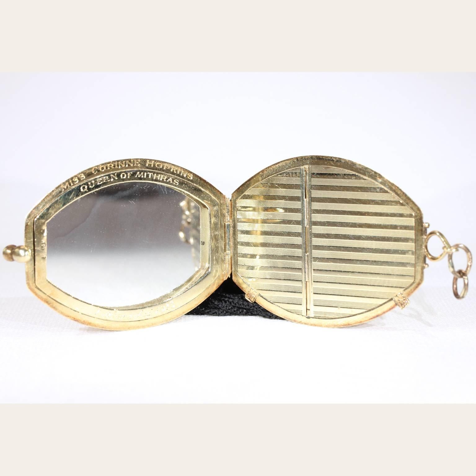 This vintage Art Deco gold compact pendant has a pretty sapphire catch and a fashionable black tassel drop. The front motif bears the letters, ‘CH’ within an ovular frame. The entire piece is engraved with golden structural stripes flowing