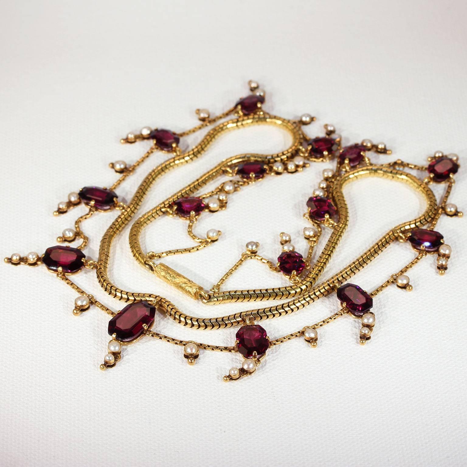 This breathtaking Victorian garnet and pearl gold necklace was handcrafted in England around 1850-60 and comes inside its original fitted box. The double chain measures 16.25 inches in length and is made up of a snake chain with a looping link