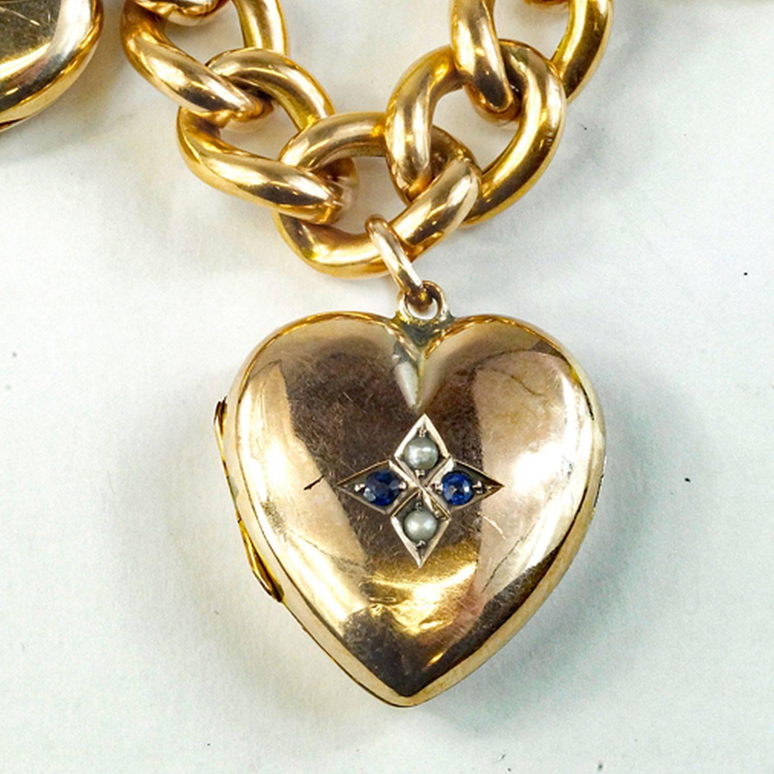 Incredible antique heart charm/locket bracelet five charms each with its own original motif and each 1 inch in diameter.  A classic 9 kt yellow gold 11 mm curb link chain bracelet that fastens with a gold pad lock heart as the clasp. Bracelet is 7