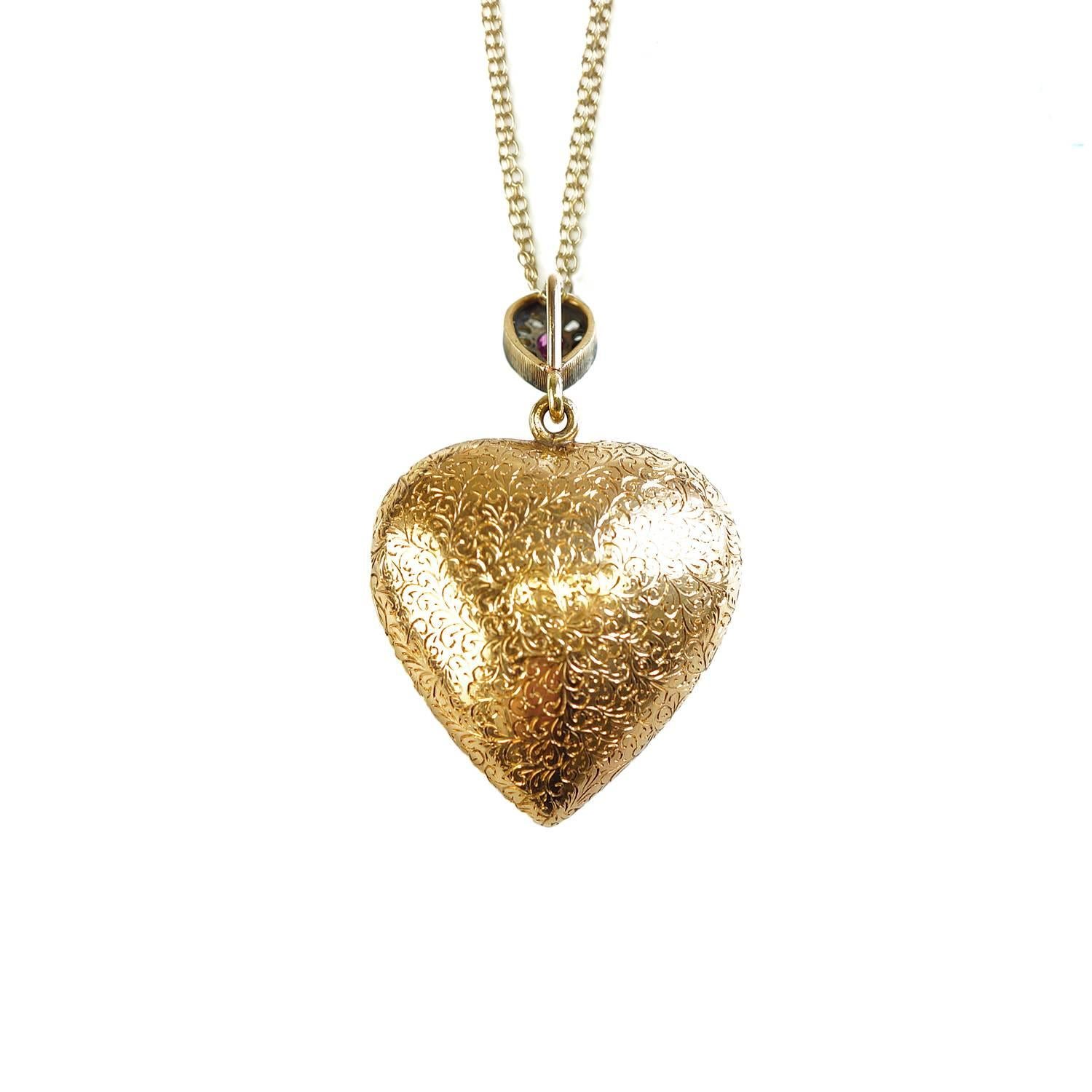 You'll treasure this 18 kt yellow gold locket with beautiful engraving front and back. A pear shape ruby in the center is trimmed with old European cut diamonds. 8 raised stars are each set with a ruby.  The pear shaped ruby bale is trimmed in old