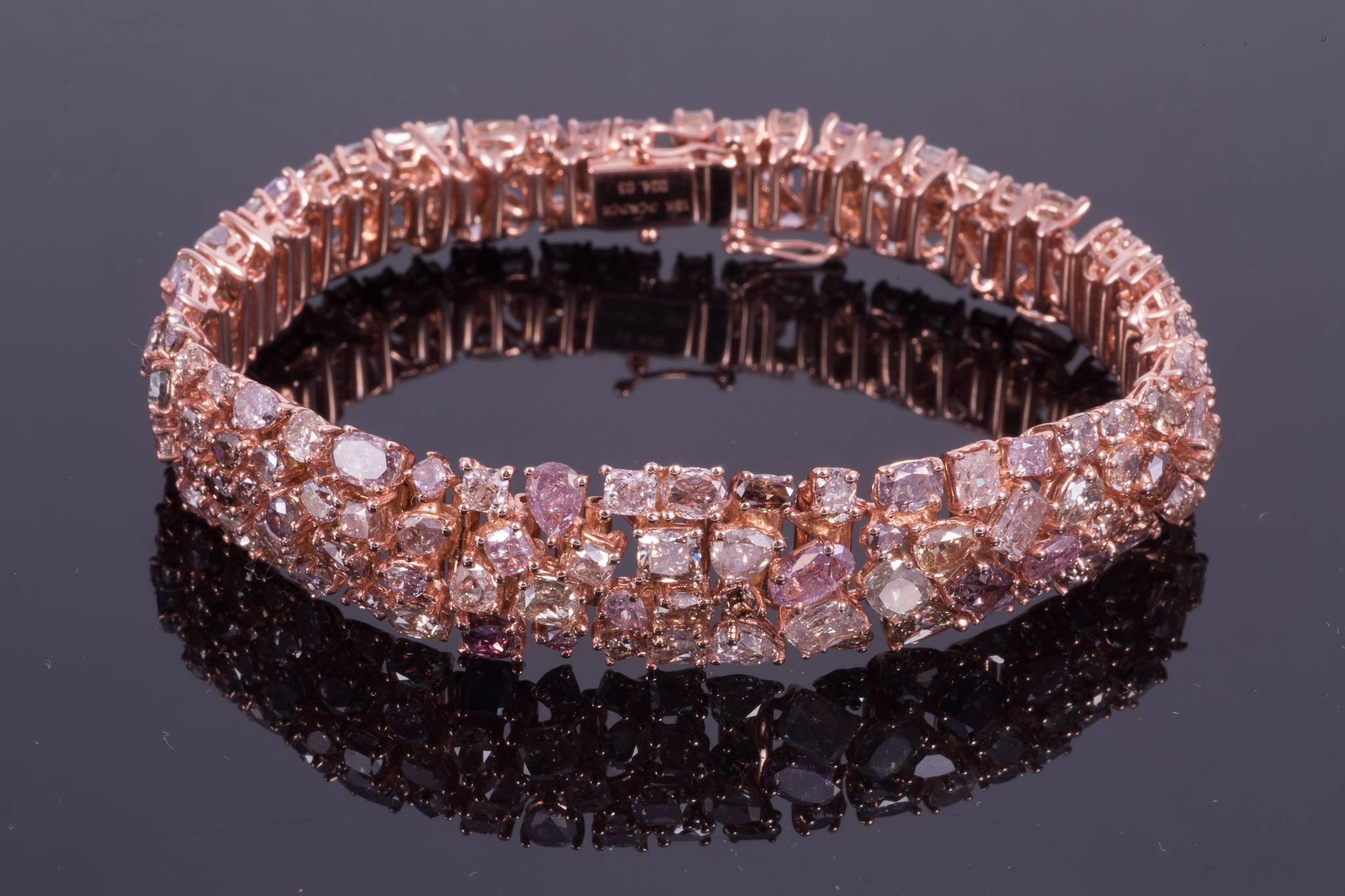 Absolutely breathtaking pink diamond bracelet. The bracelet is made up of 24.03cts of different fancy cut diamond shapes. Though the diamonds are predominately pink, there are other colors such as purple, blue, green, yellow gray and white. The