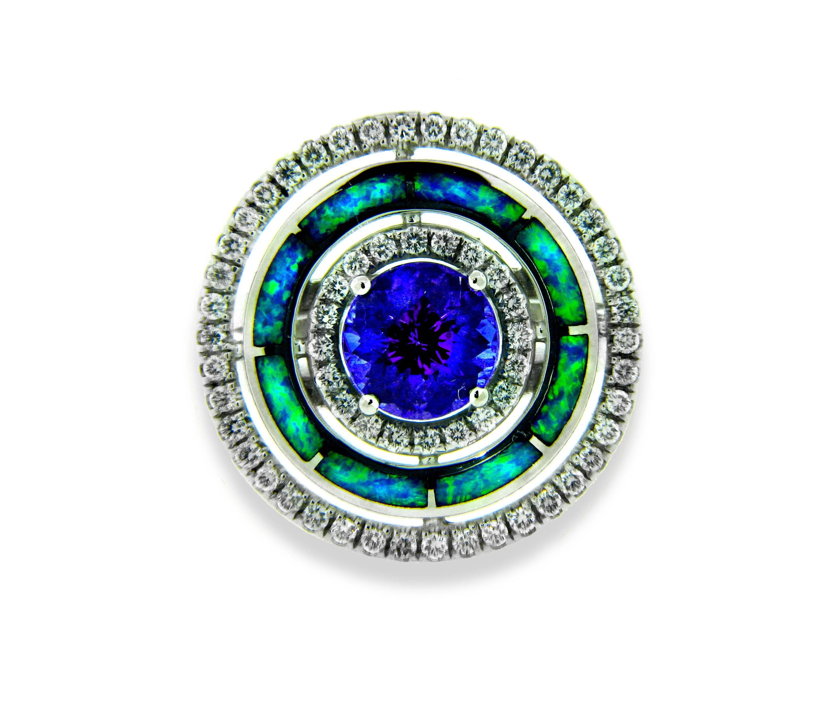 This 18kt white gold 3 tier hand-made, one-of-a-kind ring is designed by Santa Fe based artist, Danuta. It features a brilliant 2.4ct Tanzanite center gem of a deep royal blue-violet which is radiantly faceted to catch the light-and everyone's