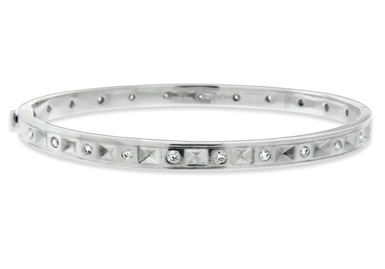 This 18 karat white gold bangle bracelet by Danuta is perfect as a solitary piece or to stack with others! Inset twinkling white diamonds (totaling .75 carats) continue around the entire design so there is never a plain side showing. For some added