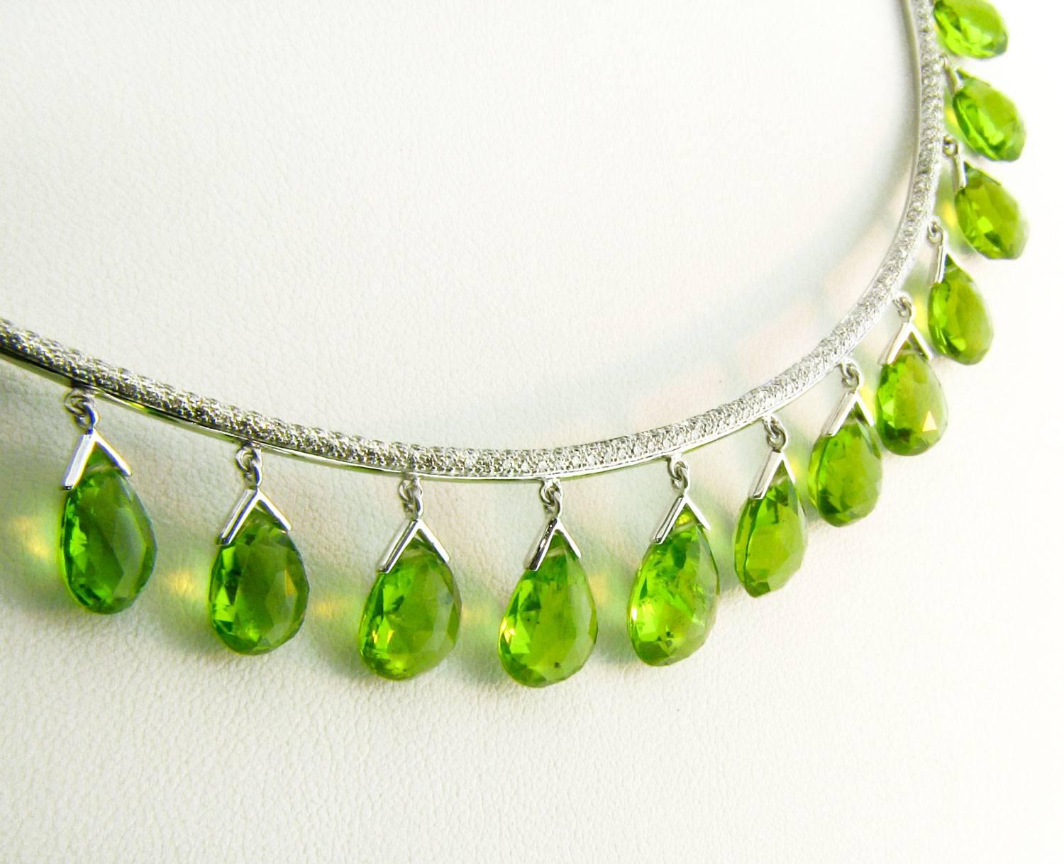 A stunning new collar necklace design by Danuta in 18 kt white gold. 
The top of the collar is intricately set with 2.67 carats of pave white diamonds (FVVS1).
Nearly all the way around this piece dangle elegant Peridot Briolettes totaling 76.48