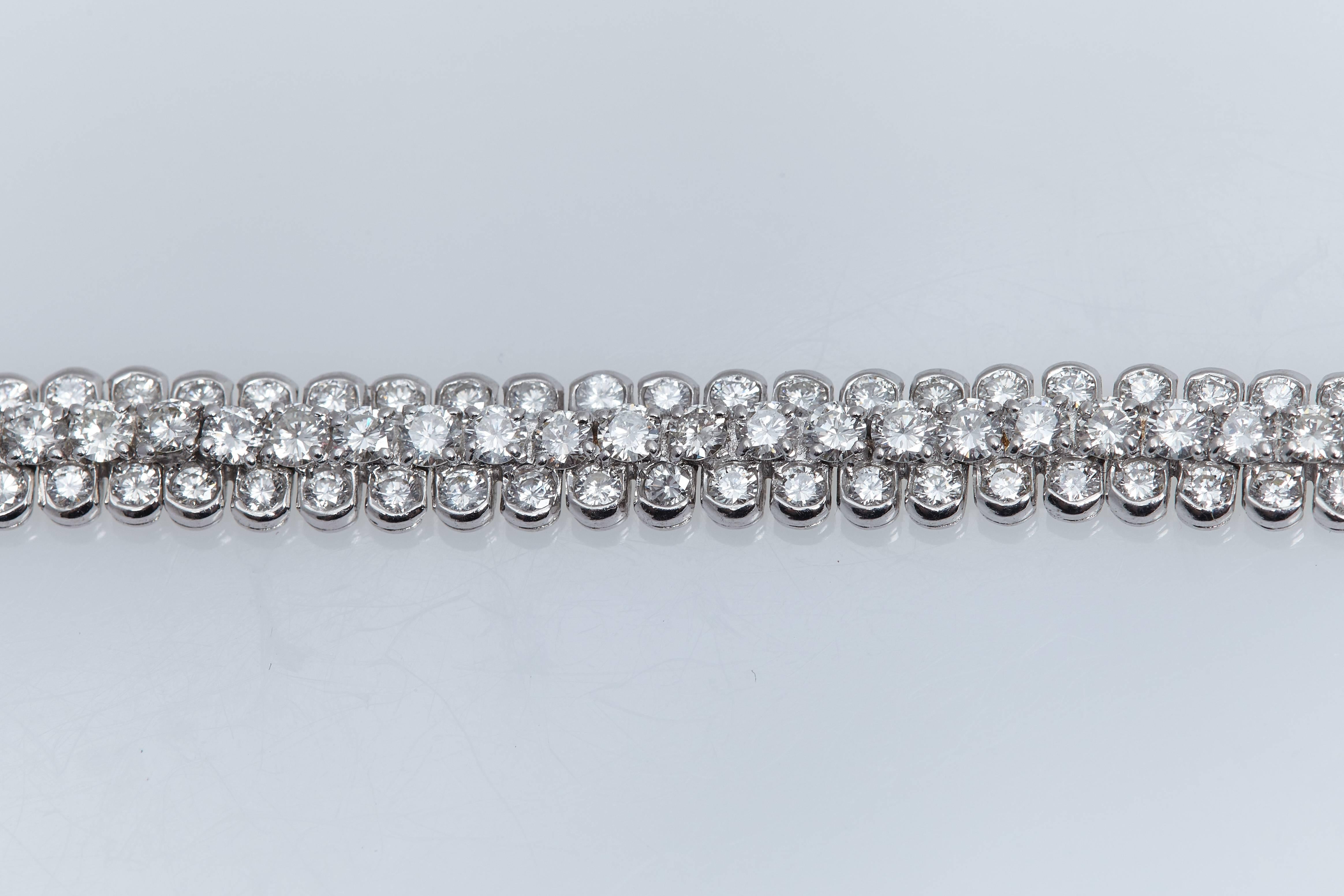 Van Cleef & Arpels diamond and eighteen karat white gold flexible bracelet.  The bracelet has 3 rows with the middle row being slightly raised above the two outside rows.  It is made up of 162 round diamonds and weighs approximately 9.50 carats.