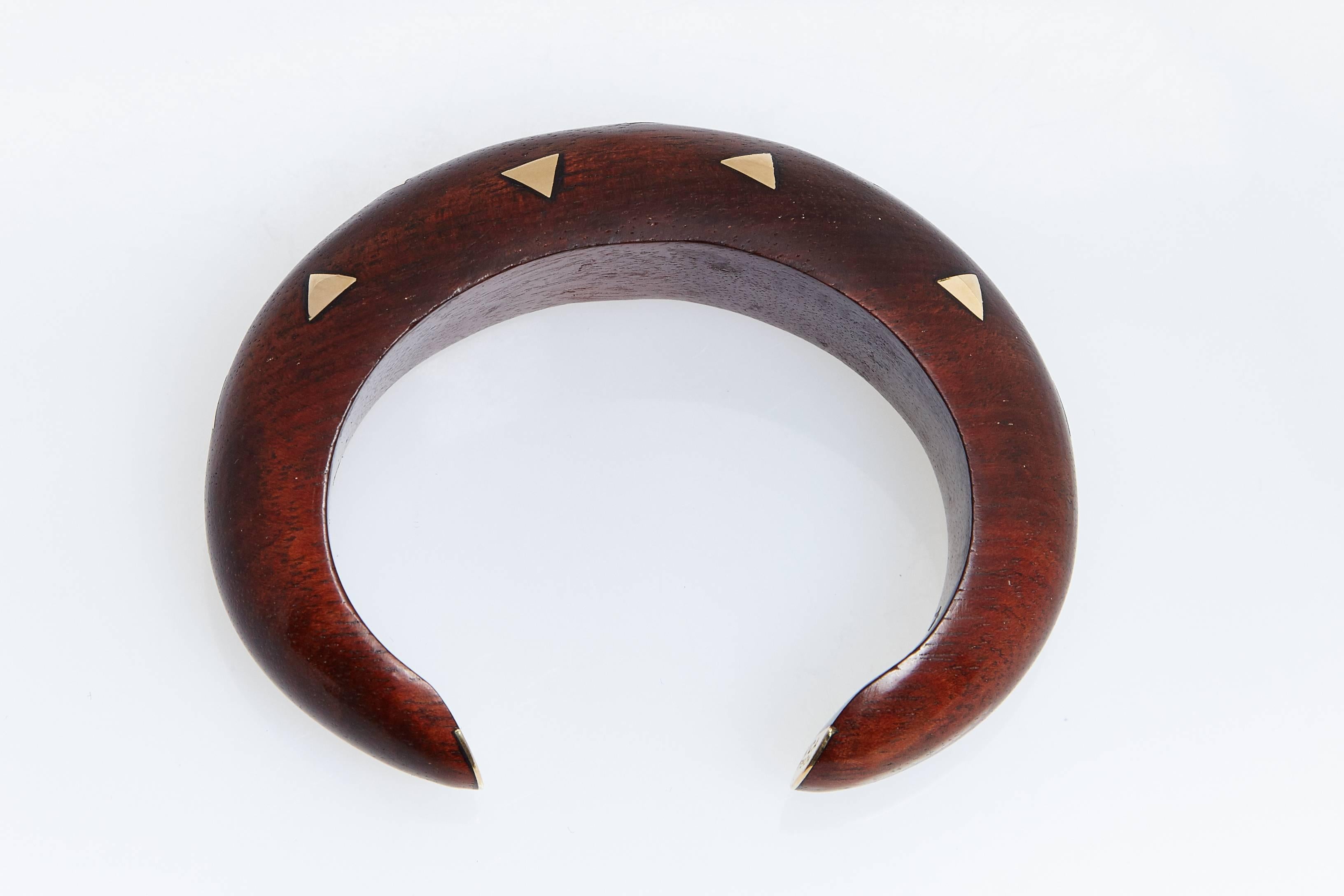      A beautiful rosewood wood and 18 karat yellow gold cuff bracelet by Van Cleef & Arpels.  The  wood is interspersed with gold triangles. The tips are gold and signed "VCA 750" and "B2587 B34".  The bracelet fits is 1 inch