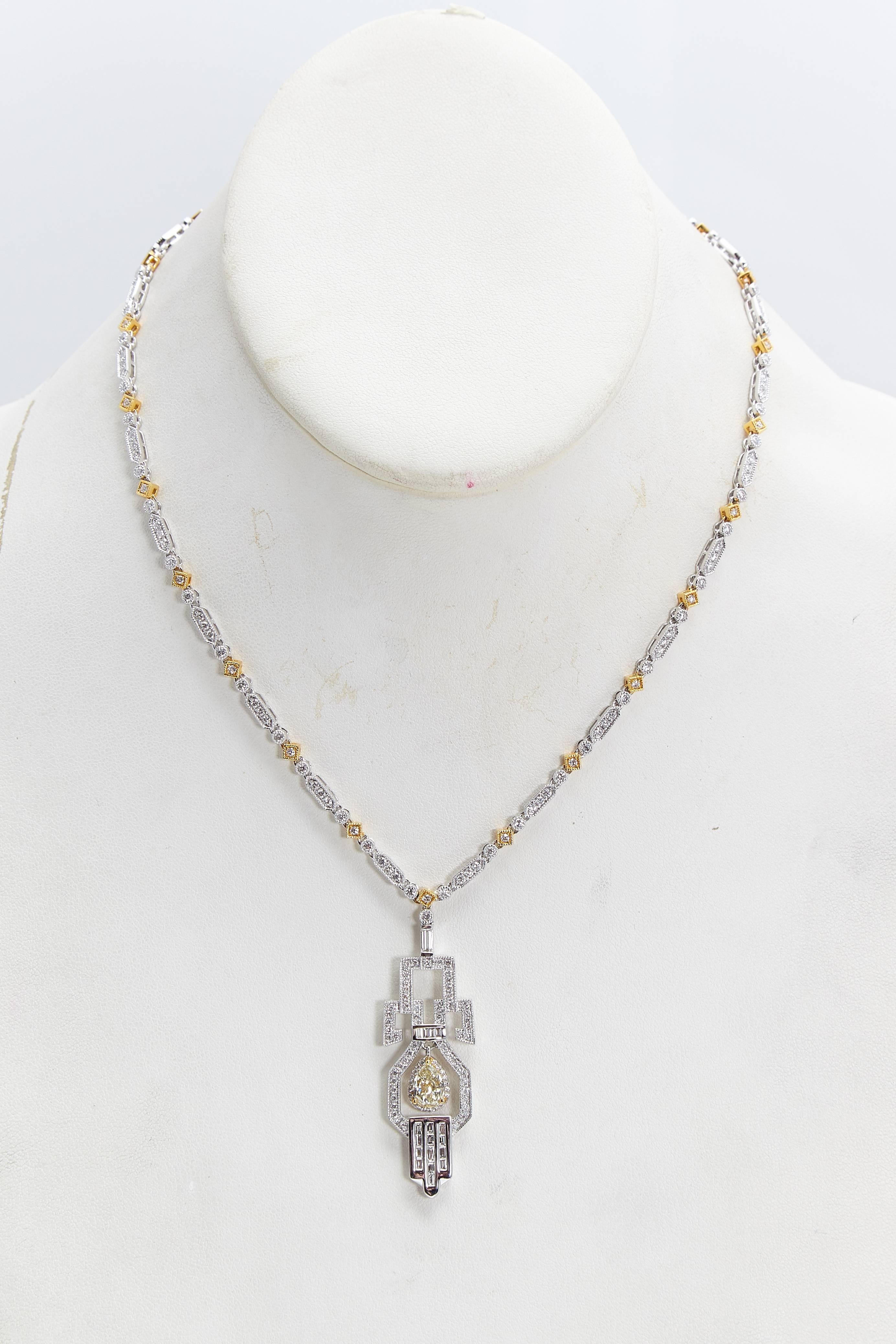 Beautifully designed diamond and eighteen karat white and yellow gold art deco styled pendant necklace.  The pendant has a yellow pear shaped diamond in the center weighing 1.02 carats and 3.30 carats of white diamonds in the necklace and the