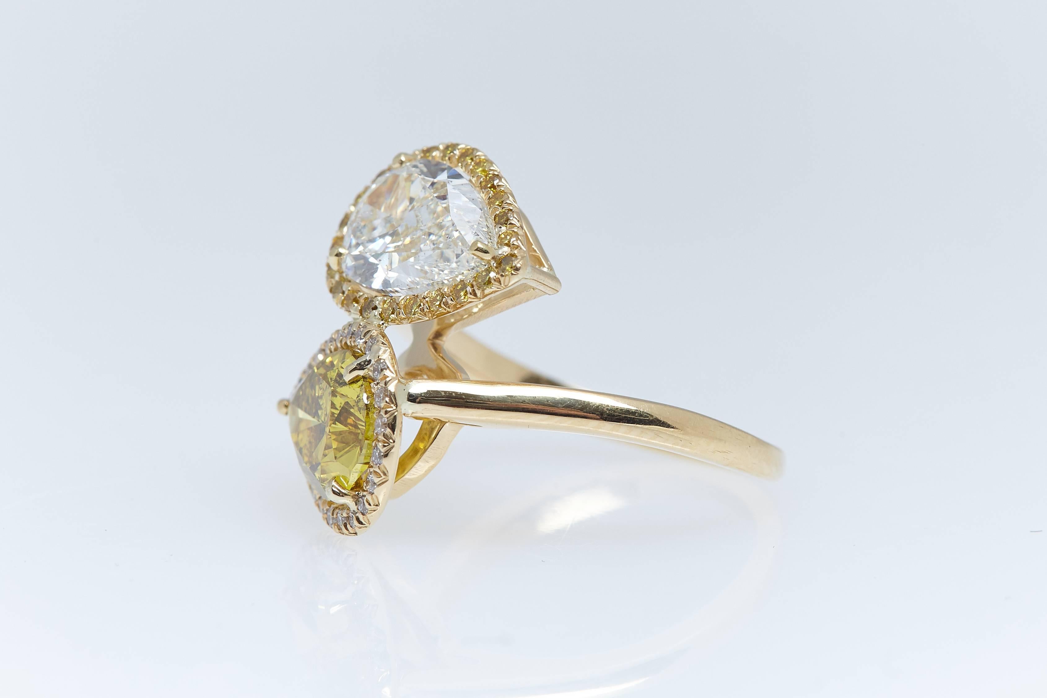 Two Pear shaped diamonds with a total weight of 4.03 carats in 18 karat yellow gold crossover designed ring. Both pear shaped diamonds have certificates from the Gemological Institute of America. One pear shape weighs 2.02 carats and is 