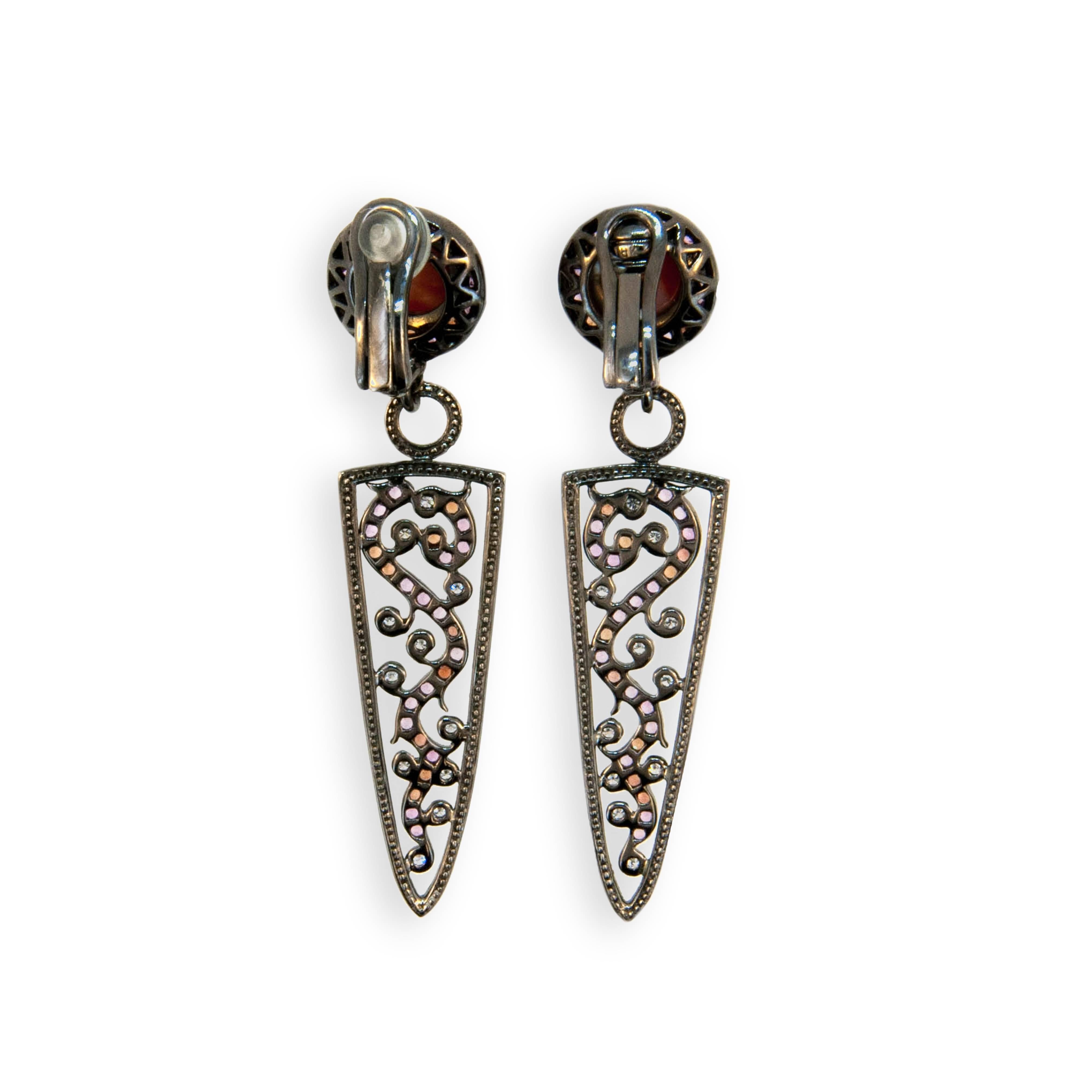 18 karat white gold blackened earrings each set with 8 mm cabochon coral weighing approx. 3.78 carats total weight, (52) pink sapphires weighing approximately 1.18 carats total weight, (30) orange sapphires weighing approximately .62 carats total