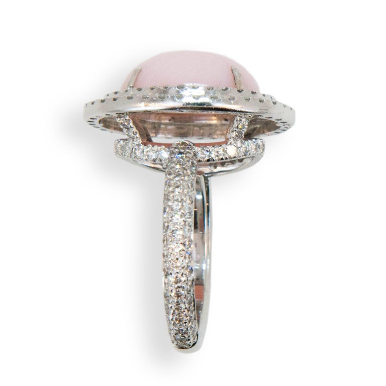 18 karat white gold ring set with an oval cab Pink Opal 5.67 carats total weight and surrounded by two rows of diamonds two hundred diamonds equal 1.94 carats total weight** Diamond weights are average/approximate. Ring size is 6 1/2.