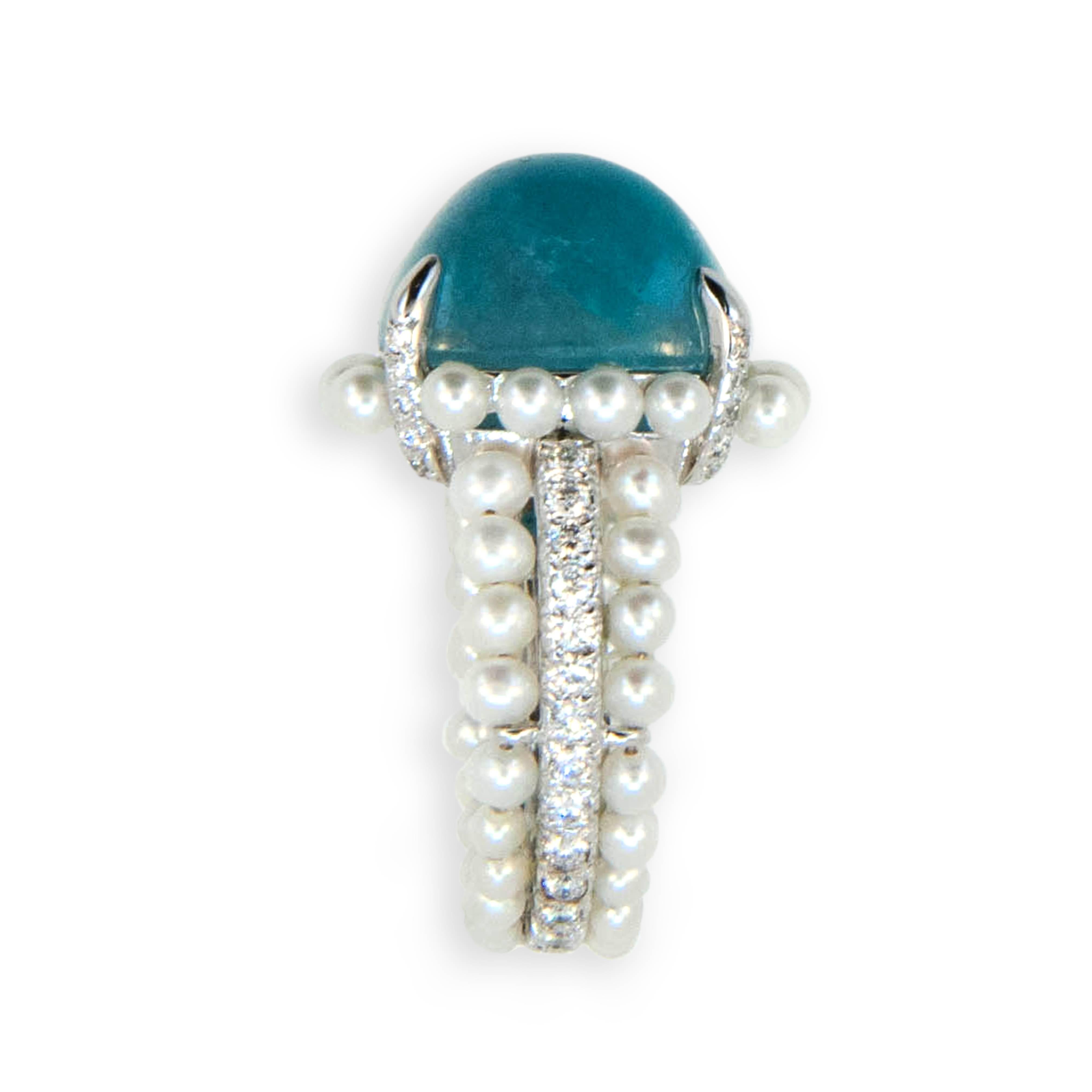 18 karat white gold ring set with one cabochon antique cushion cut Paraiba Tourmaline 11.99 carats (54) cultured Pearls are set surrounding Paraiba at base and in two outer rows of shank (51) round Diamonds are set on four prongs and in center row