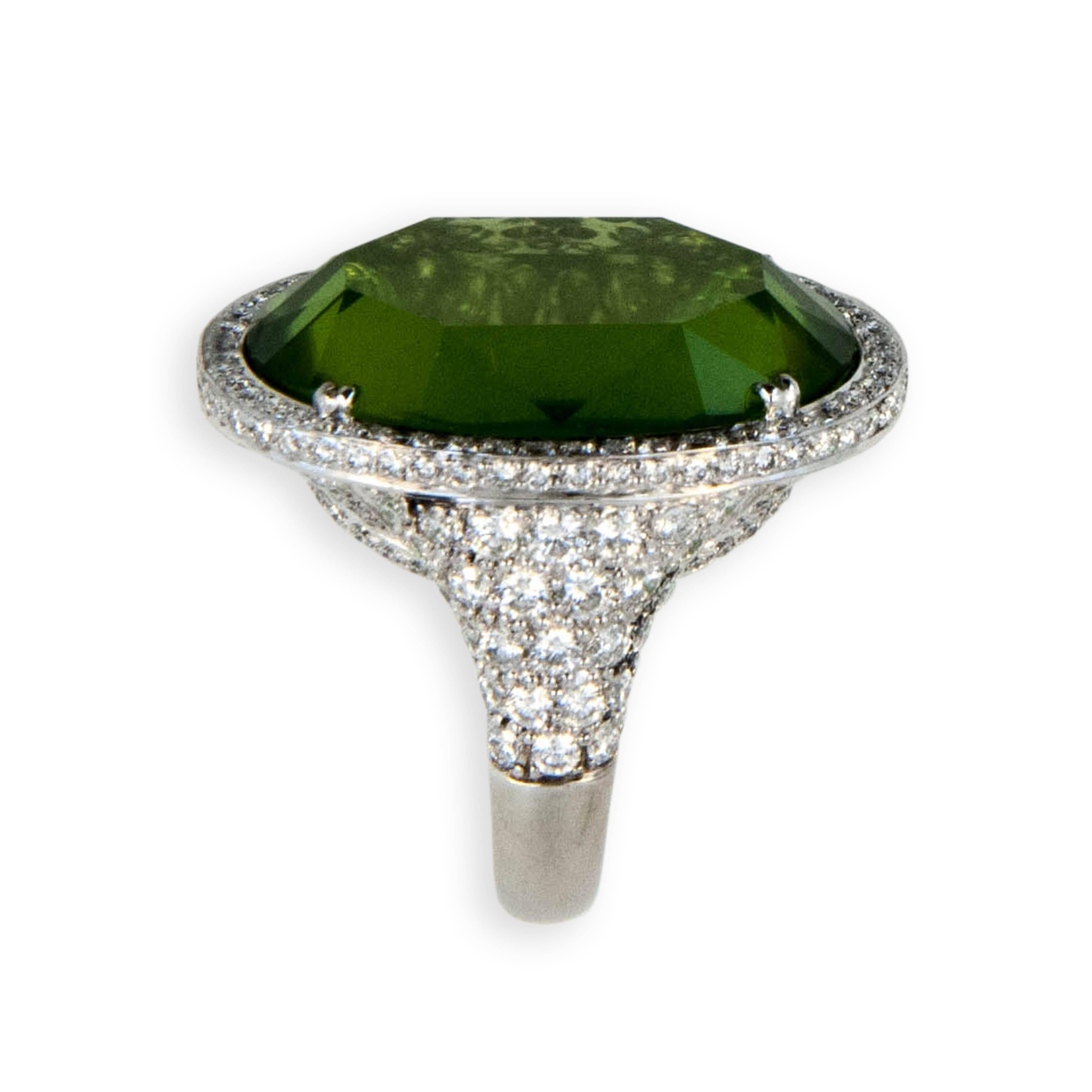 18 karat white gold ring set with one oval faceted Peridot 27.44 carats, no culet, table like facet on both sides. Bezel, under bezel and partial shank are pave' 
and microset with 222 diamonds 2.87 carats total weight. 