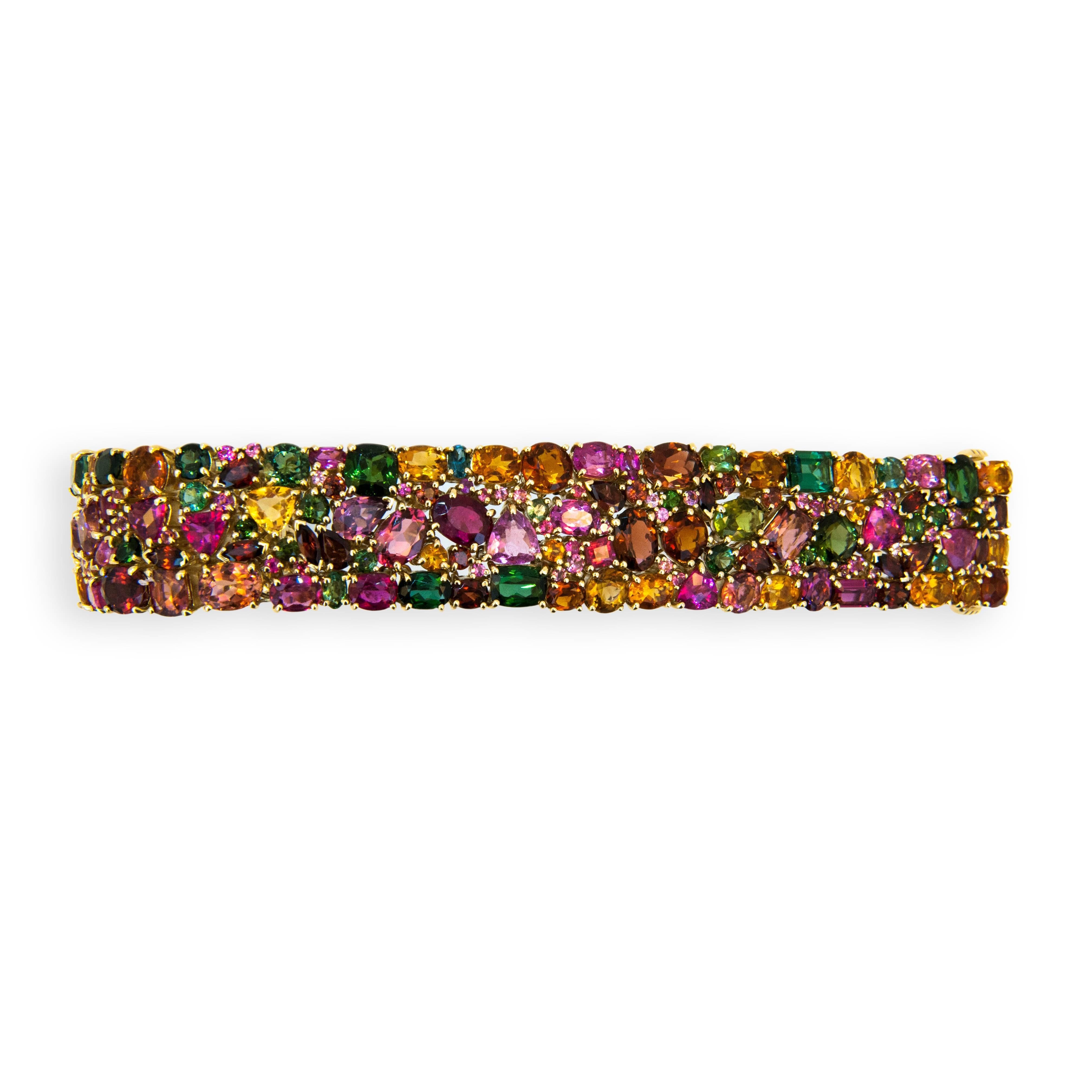 18 karat yellow gold Kaleidoscope bracelet Autumn 188 multi-colored multi-shaped Tourmaline, Garnet, Citrine, and Pink Sapphire 89.33 carats total weight. Oval,round,trillion,marquise, baguette, pear,rectangular. Slightly over 3/4 inches wide. Seven