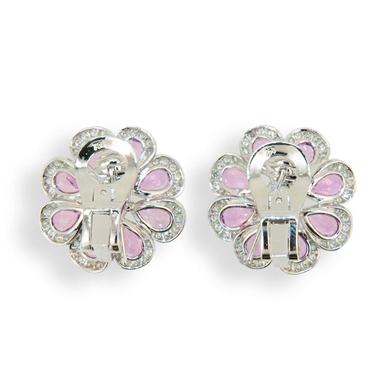 18 karat white gold earrings flower shape set with (16) pear shaped Pink Sapphires 7.73 carats total weight. Center is set with one rose cut diamond (2) .74 carat total weight. Edges of petals are set with (96) Diamonds .69 carat total weight.