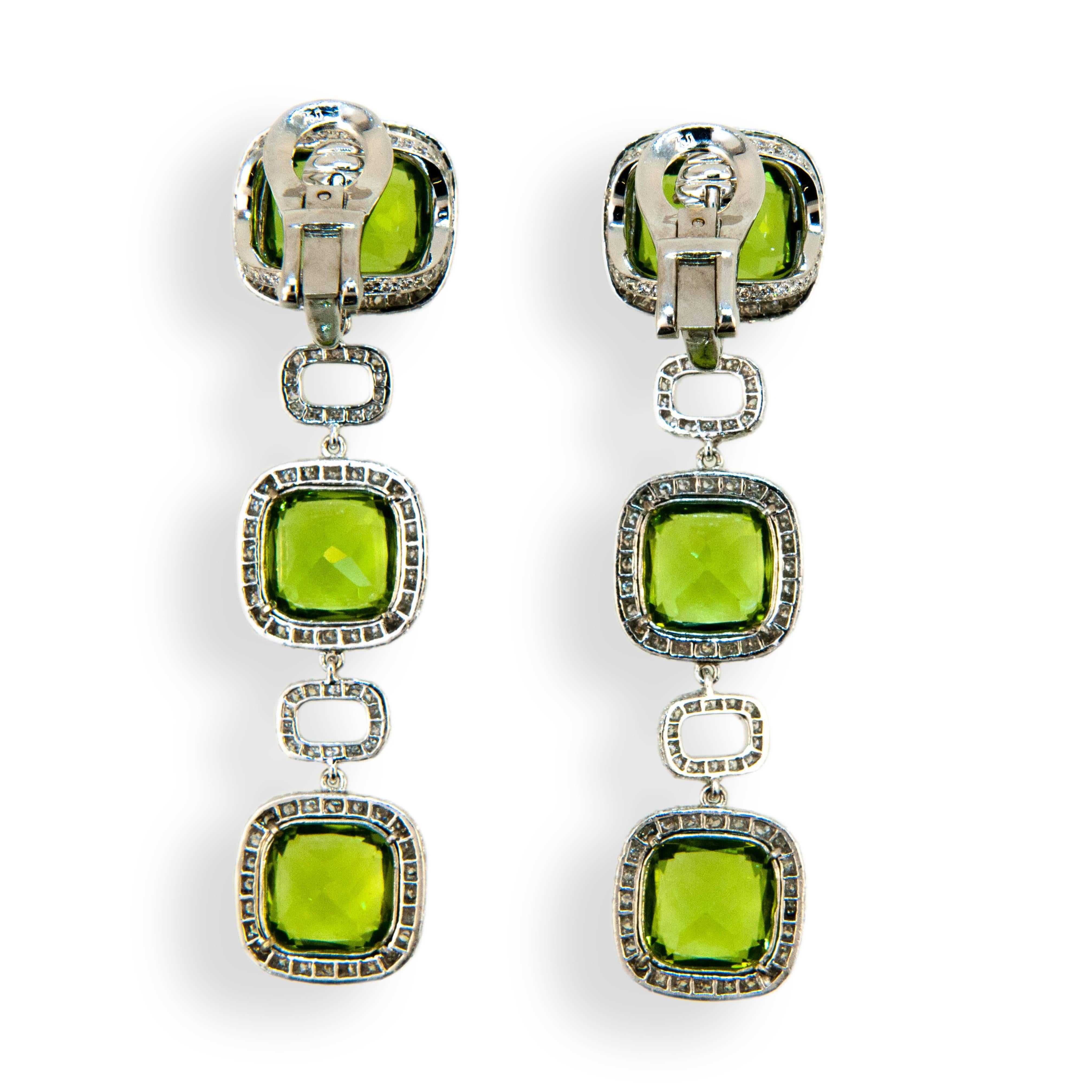 18 karat white gold earring 12 x 10 mm Peridot at top with two 9.5 x 9.5 mm Peridot below 28.90 carats total weight with 542 micro set diamonds surrounding and rectangular diamond sections separating 3.46 carats total weight. Earrings may be worn as