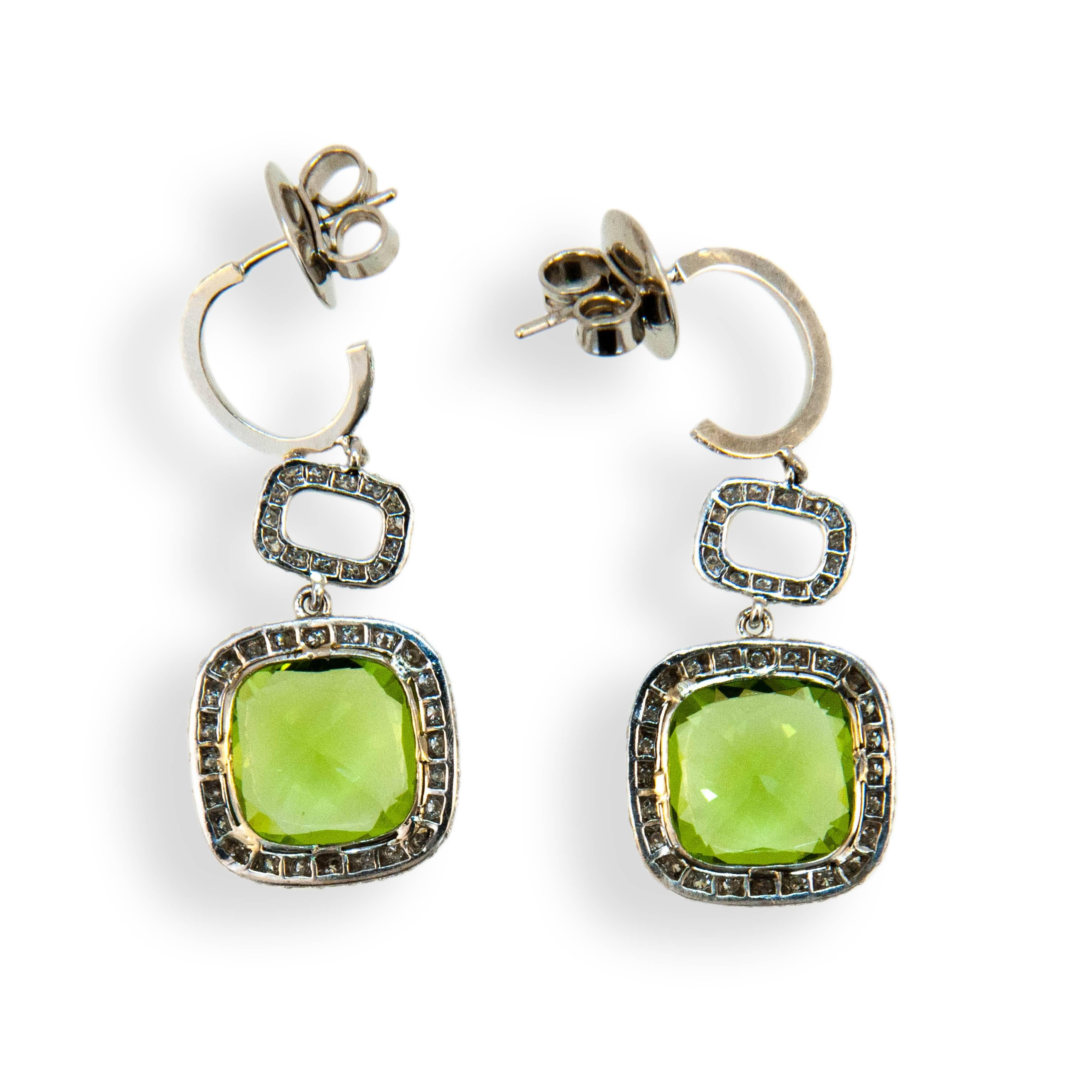 18 karat white gold earrings each set with one 10 x 10 mm cushion cut Peridot 3.36 carats and 3.66 carats. Set in each hoop are (18) diamonds .15 carat total weight. Surrounding Peridot and in connecting link are (85) diamonds 170 total