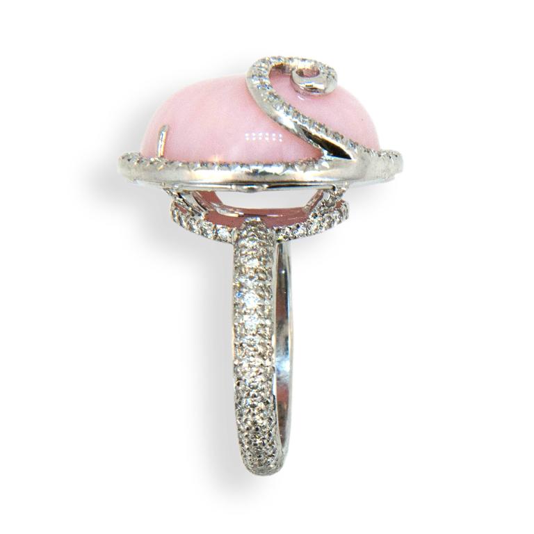 18 karat white gold ring set with oval cab Pink Opal 13.57 carats total weight with diamond swirl on top and diamonds surrounding and down shank 185 diamonds total 1.23 carats total weight. Ring is a size 6.25 with a horseshoe.