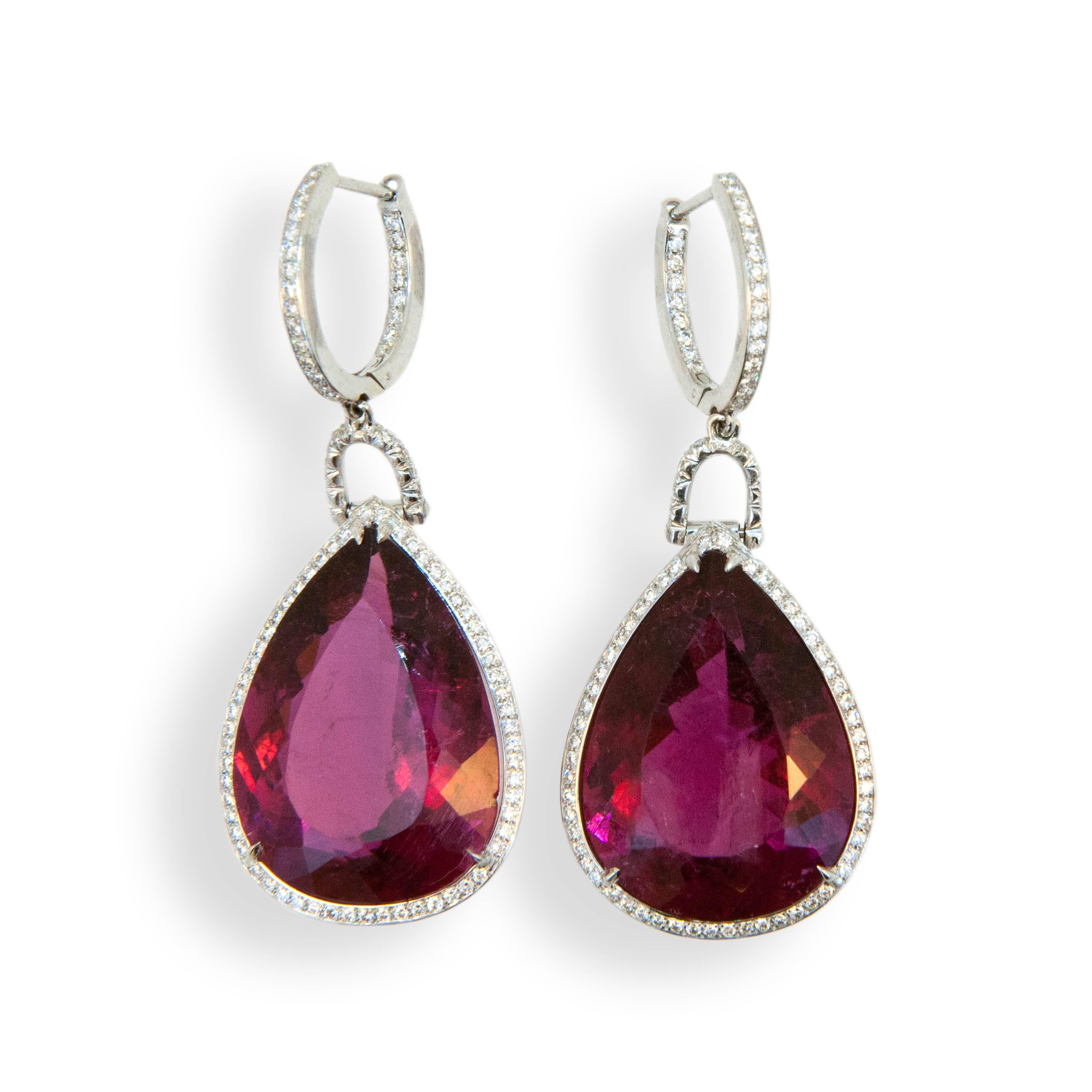 18 karat white gold earrings each set with one faceted pear shaped Rubellite Tourmaline 15.80 carats and 15.65 carats. Diamond hoop is set with (23) diamonds (46) total .19 carat total weight each connecting link is set with (8) diamonds (16) total