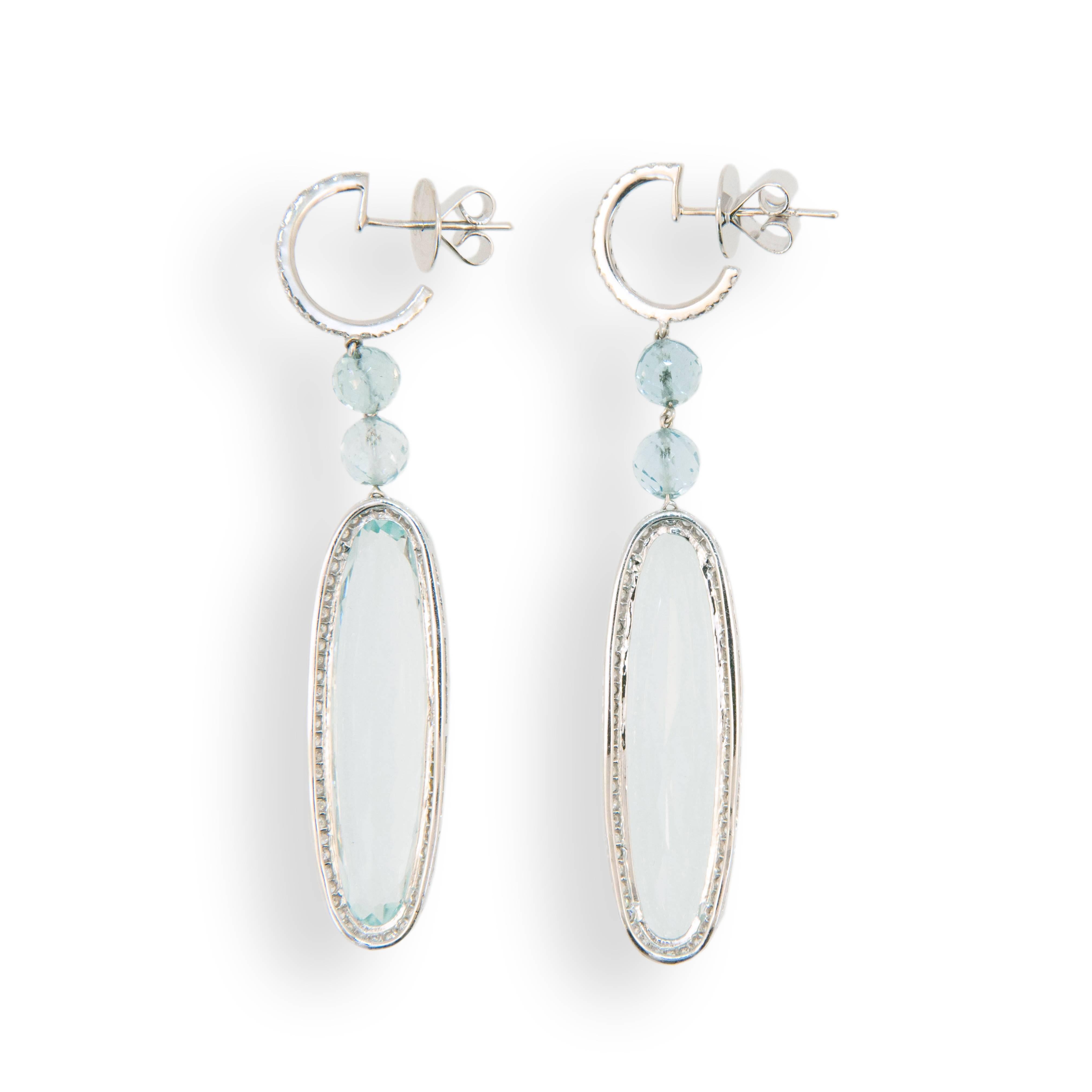 18 karat white gold drop earrings set with (2) long oval Aquamarines 34.18 carats total weight. Approximately 1 3/8 inches length, four faceted Aquamarine beads 5.36 carats total weight and 156 micro set round Diamonds 1.13 carats total weight. Top