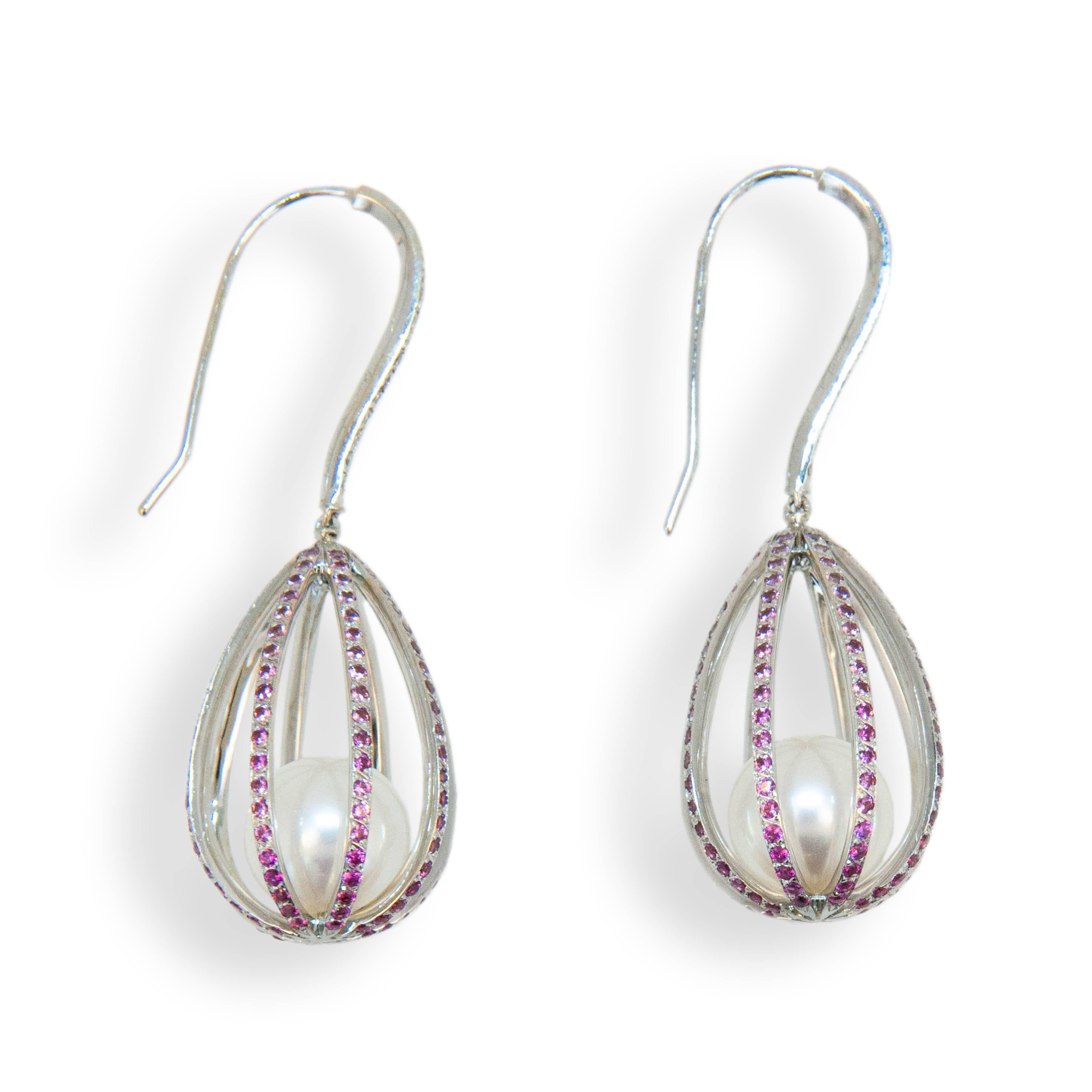 18 karat white gold earrings small cage style earrings with 9 mm cultured Akoya pearls. Cages are micro set with 320 1 mm Pink Sapphires graduating in color from light to dark pink having a total weight of 1.72 carats total weight. Wires at top are