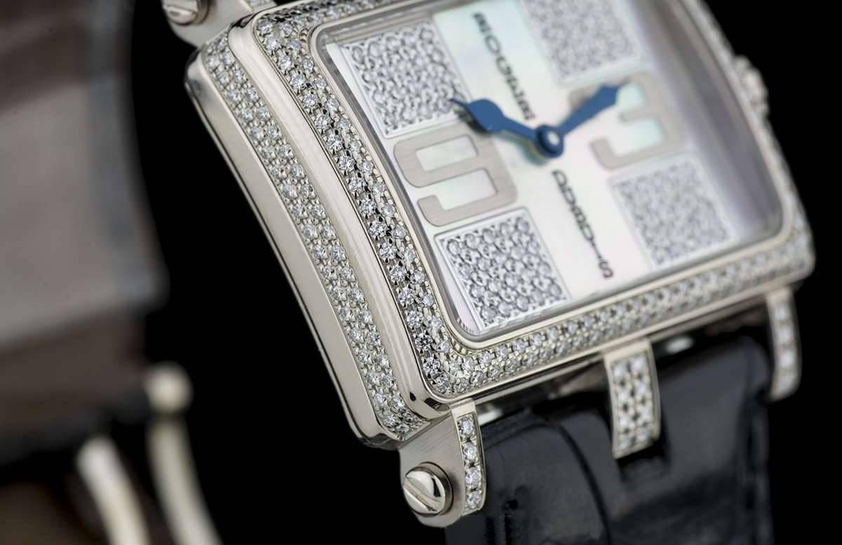 
An 18k White Gold Too Much Ladies Wristwatch, white mother of pearl (MOP) and pave set diamond dial with applied arabic numbers 3 and 9, dial is set with approximately 80 round brilliant diamonds, an 18k white gold fixed bezel set with two rows of