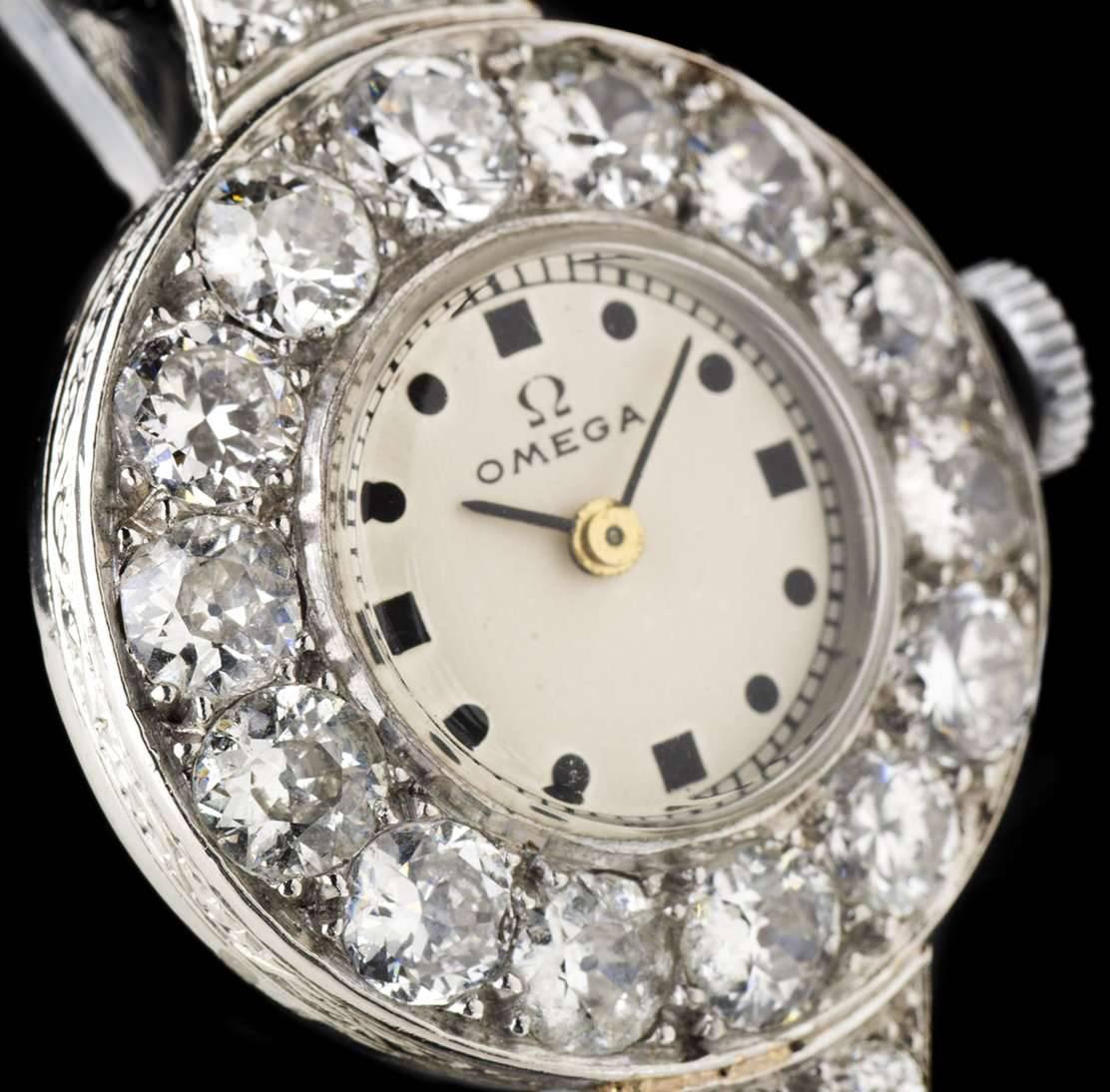 A Platinum Diamond Set Vintage Ladies Wristwatch, white dial with hour markers, a fixed platinum bezel set with approximately 14 round brilliant cut diamonds, platinum lugs each set with 3 round brilliant cut diamonds, a black rope bracelet with a