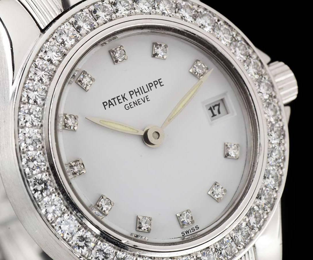 A White Gold Neptune Ladies Wristwatch, white dial with 11 applied round brilliant cut diamond hour markers, date at 3 0'clock, a fixed white gold bezel set with approximately 36 round brilliant cut diamonds, a white gold bracelet with a white gold