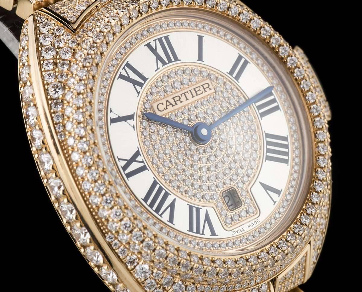 An Unworn Rose Gold Fully Loaded Diamond Set Clé De Cartier Ladies Wristwatch, pave diamond dial with roman numerals and a secret signature at "X", blued steel sword shaped hands, date at 6 0'clock, a fixed rose gold diamond set bezel,
